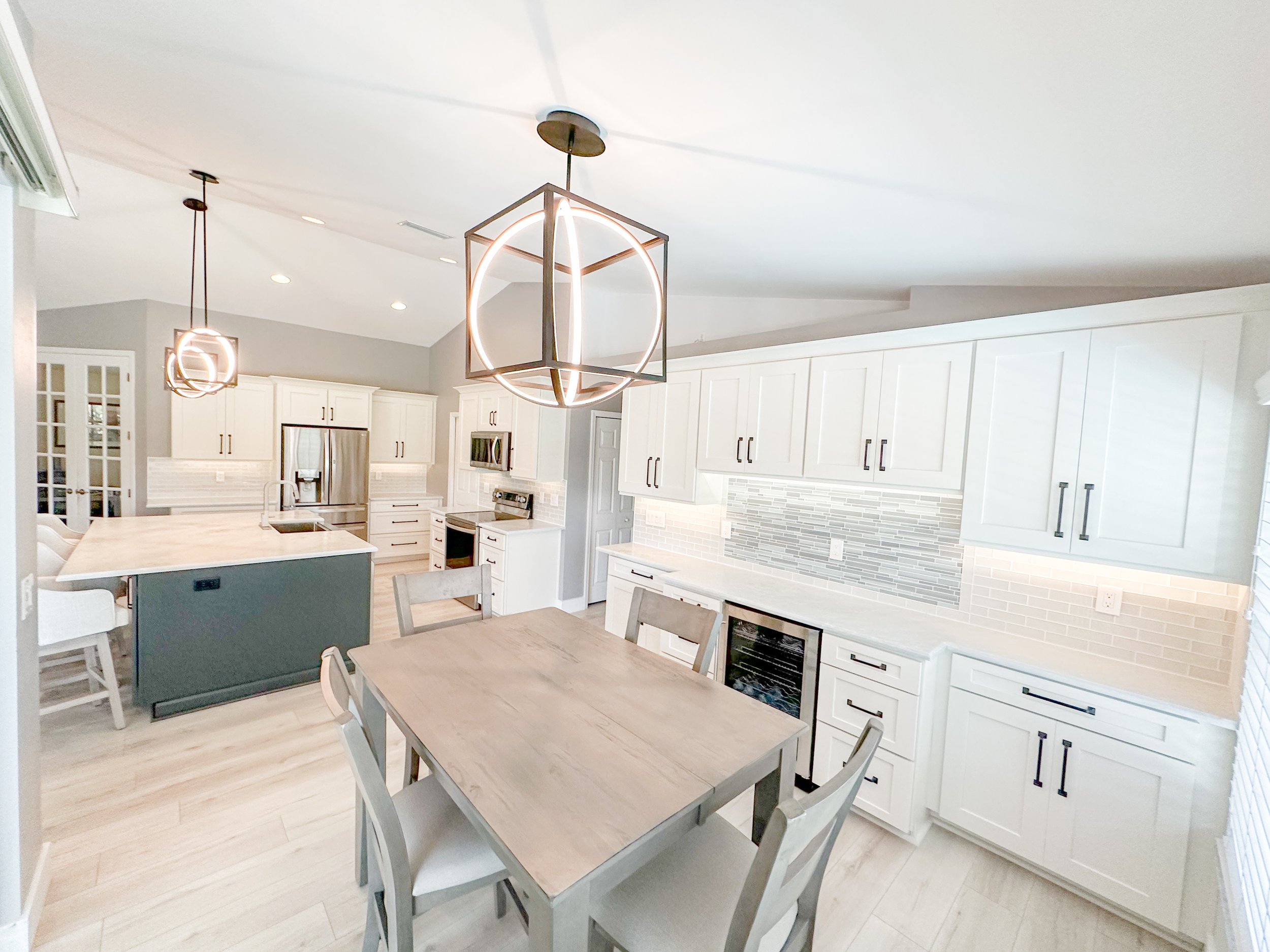 Modern kitchen with white cabinets and lights wood flooring