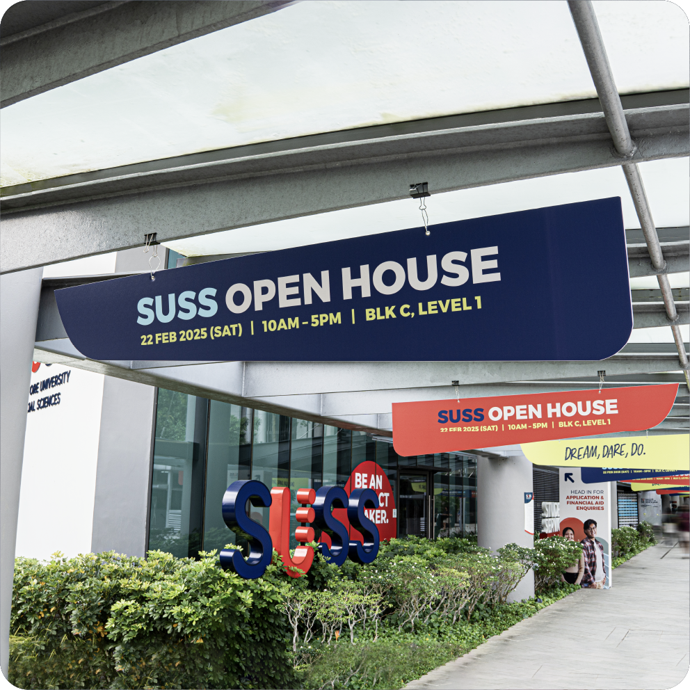 Signages for SUSS Open House event outside a university building with green bushes and posters in the background by Studio Mojo - branding design, event design, exhibition design, event company Singapore