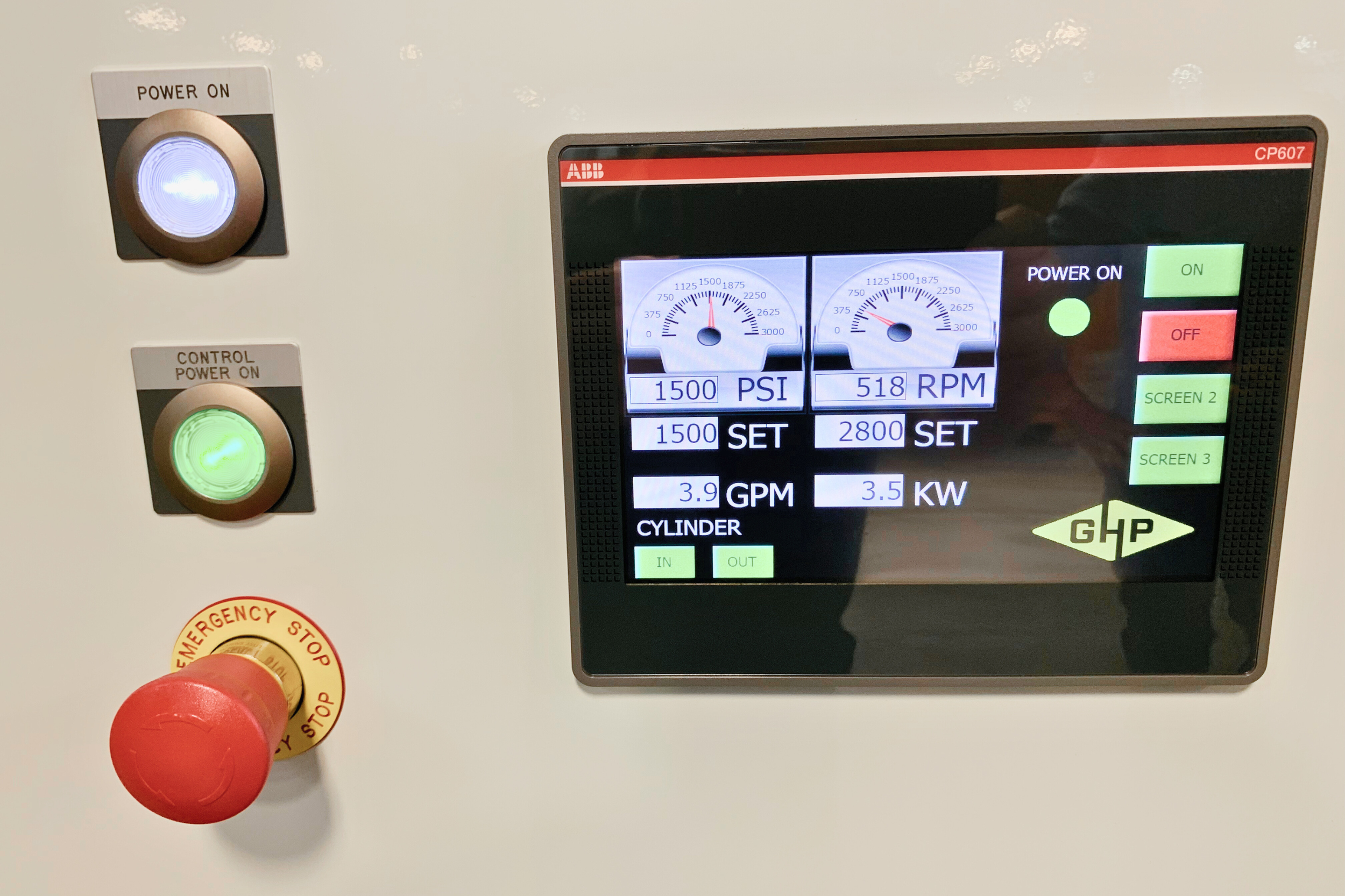 Control panel with gauges displaying PSI and RPM, an electronic screen showing operational data, and buttons including a green 'ON' button, a red 'OFF' button, and an emergency stop button.