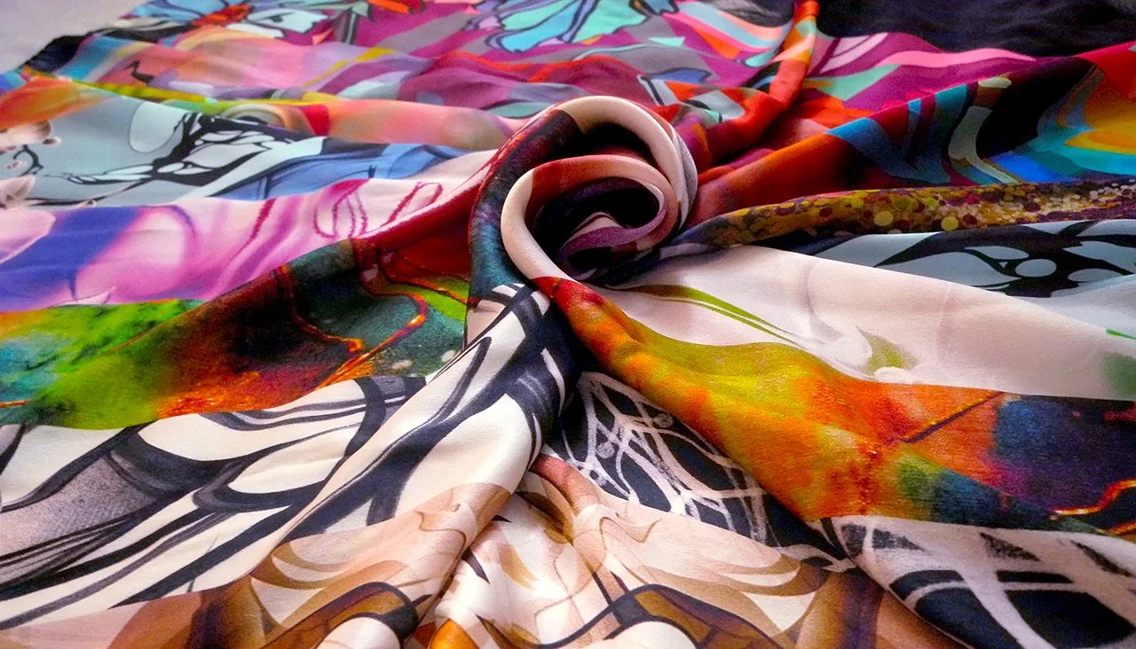Colorful, abstract fabric with various vibrant patterns and swirls, arranged with a spiral fold in the center.