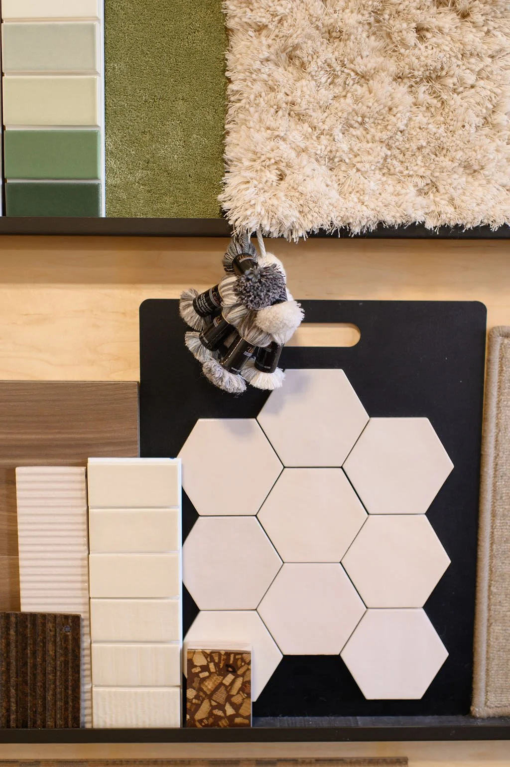 Display of various tile samples, fabric swatches, and color options for home interior design, arranged on a flat surface.