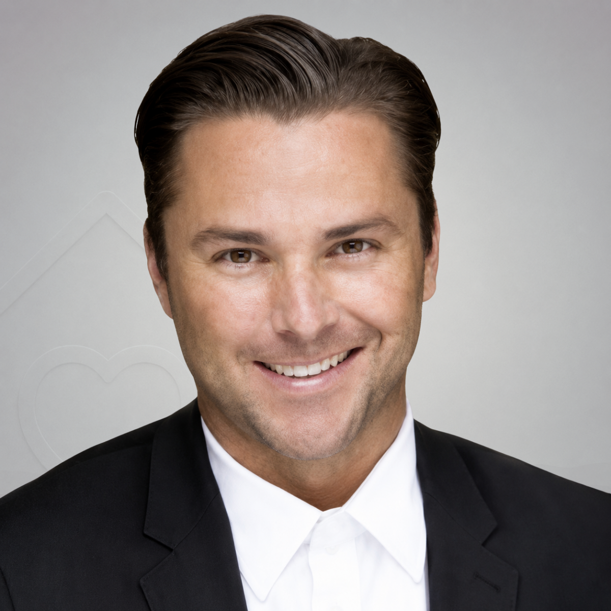 Portrait of a man with slicked-back dark hair, wearing a black tuxedo with a white shirt.