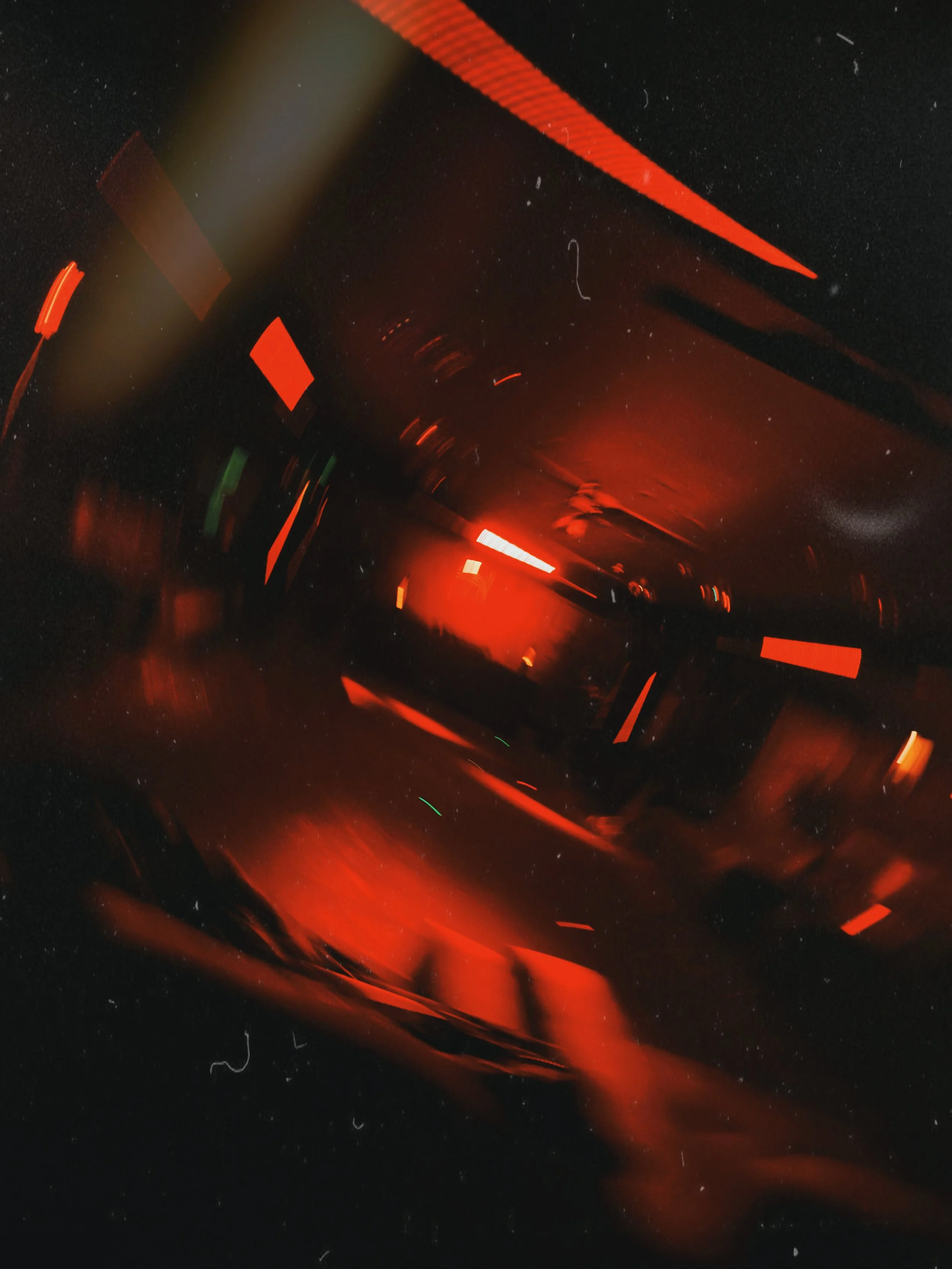 Imagen abstracta con luces y destellos rojos, negros y verdes, con efecto de movimiento y desenfoque.