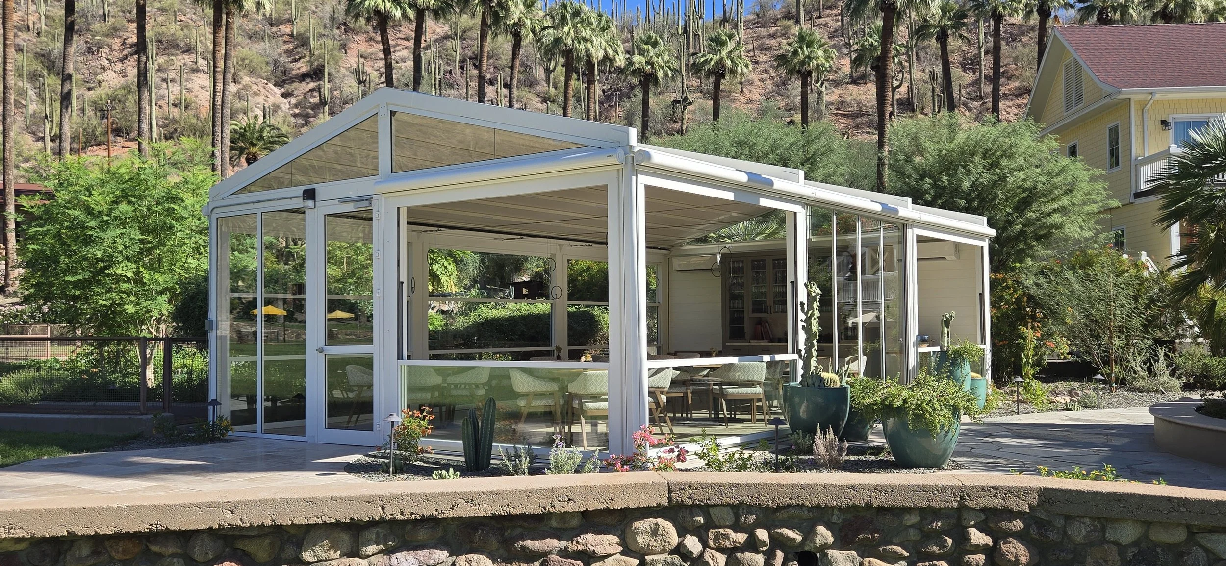 Vertical glass walls enclosing mountain-view dining space with natural light.