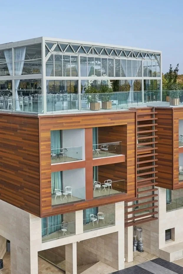 Modern rooftop pavilion structure with full-height glass and open-air terrace