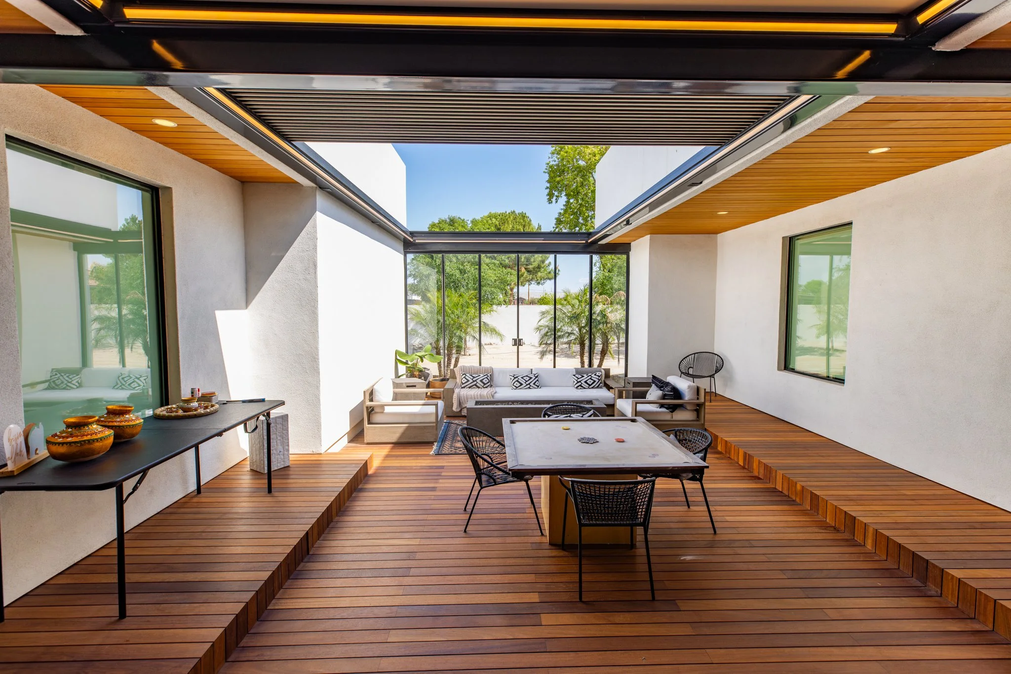 Retractable roof system over restaurant deck with glass walls and ocean view.