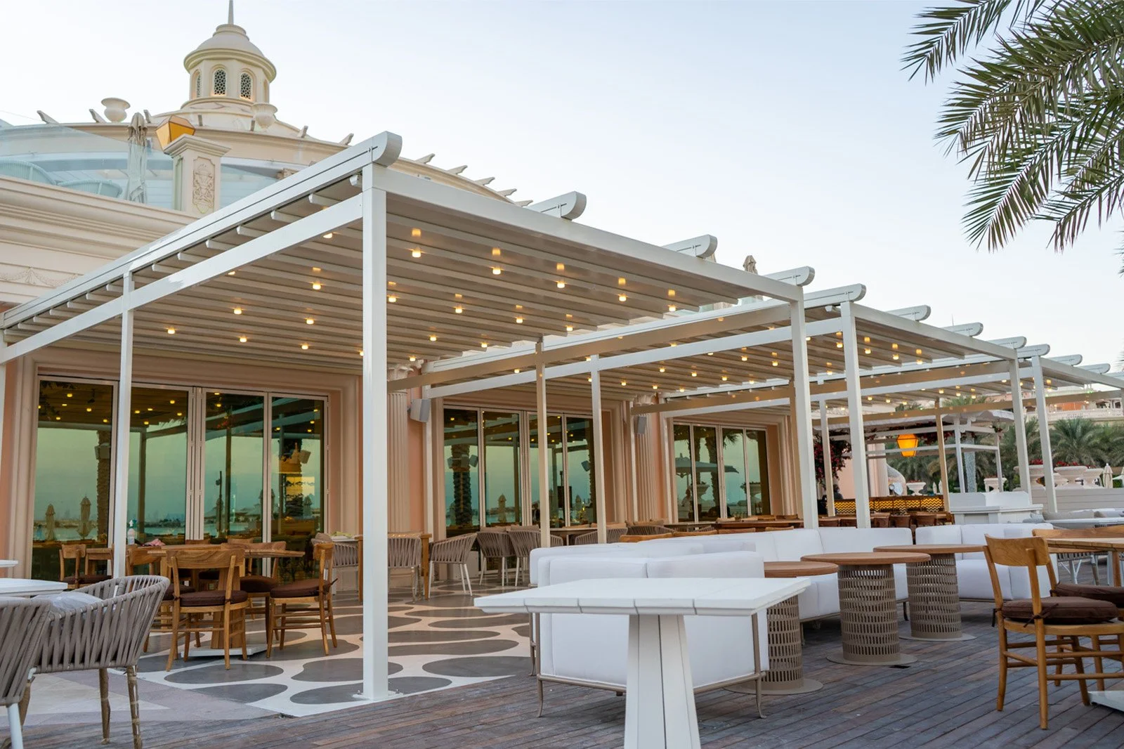 Luxury resort patio with linear pergolas and string lighting.