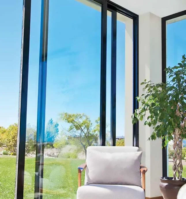 Slim-framed insulated sliding glass panels providing thermal comfort in a bright lounge.