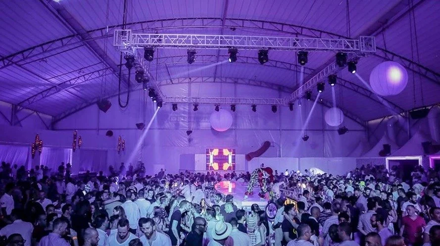 Large retractable soft-top roof system transformed into a concert-style venue with professional lighting and sound.