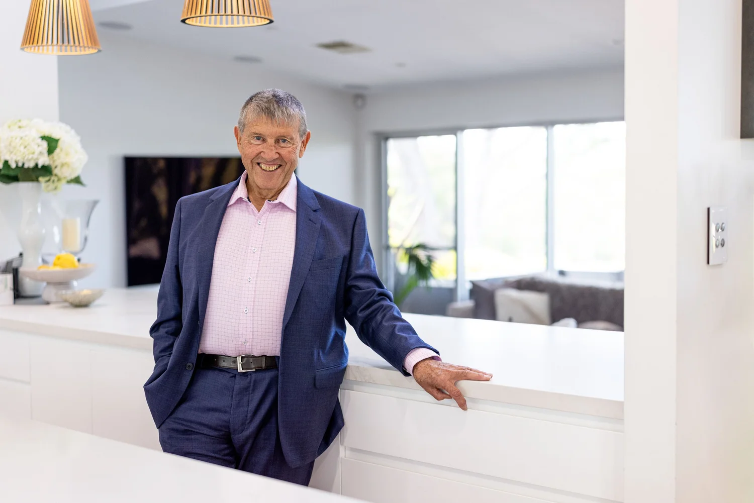 Portrait of a business owner in a navy suit in a white kitchen