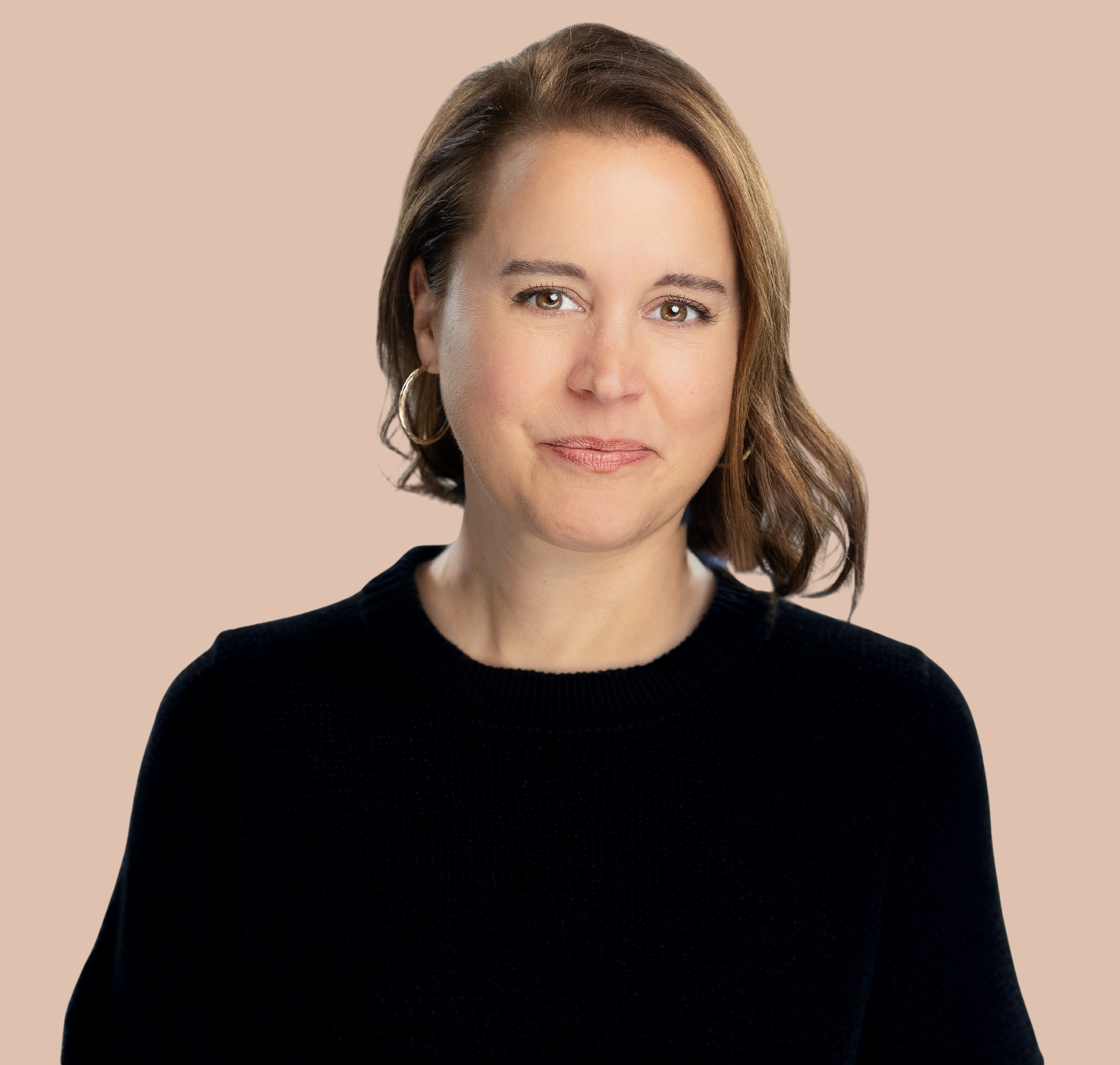 Reno Tahoe Organizing owner and home organizer with shoulder-length brown hair, wearing hoop earrings and a black top, poses against a plain beige background.