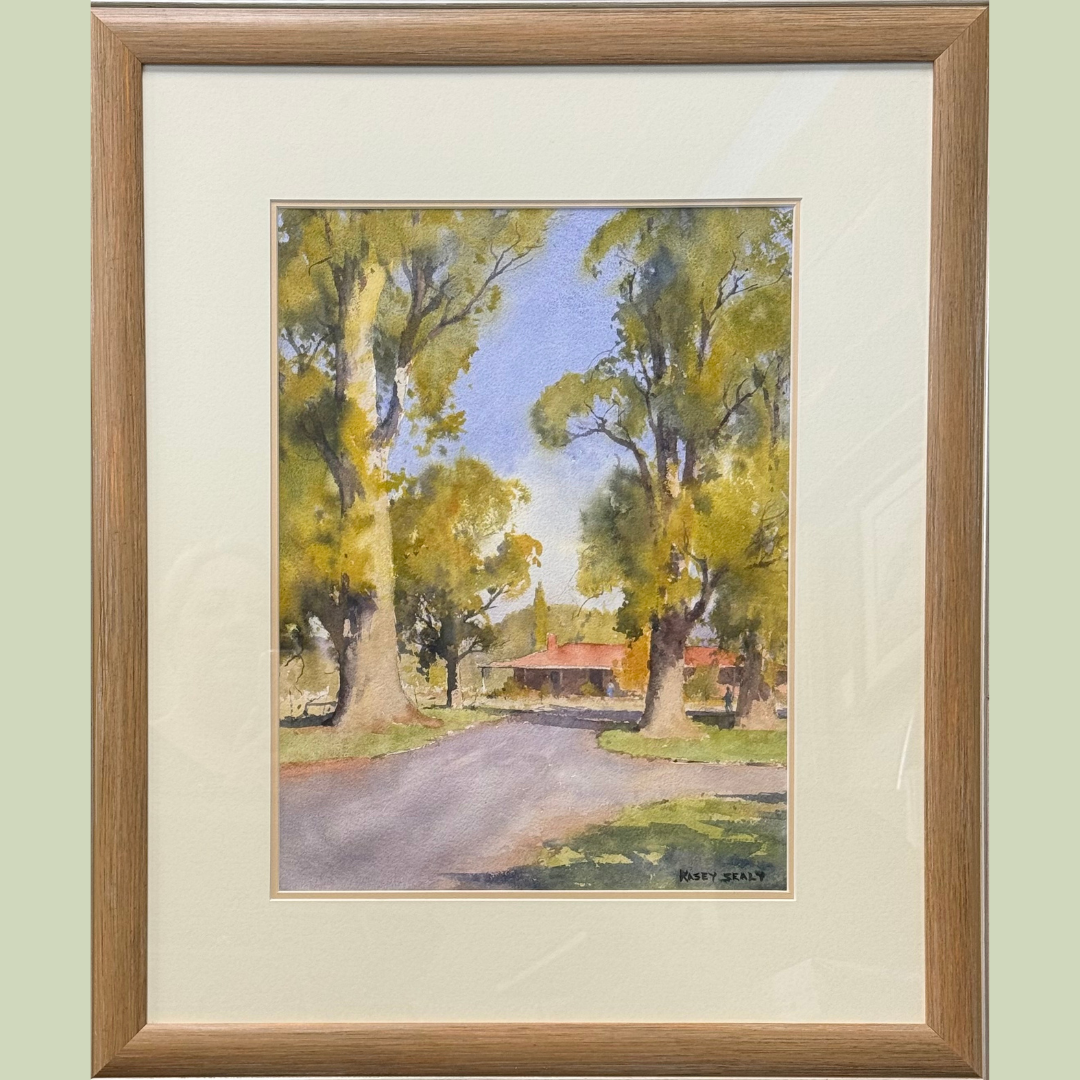 Watercolor painting of a rural scene with large trees lining a dirt road and a house with a red roof in the background, signed by Nacey Sealy.