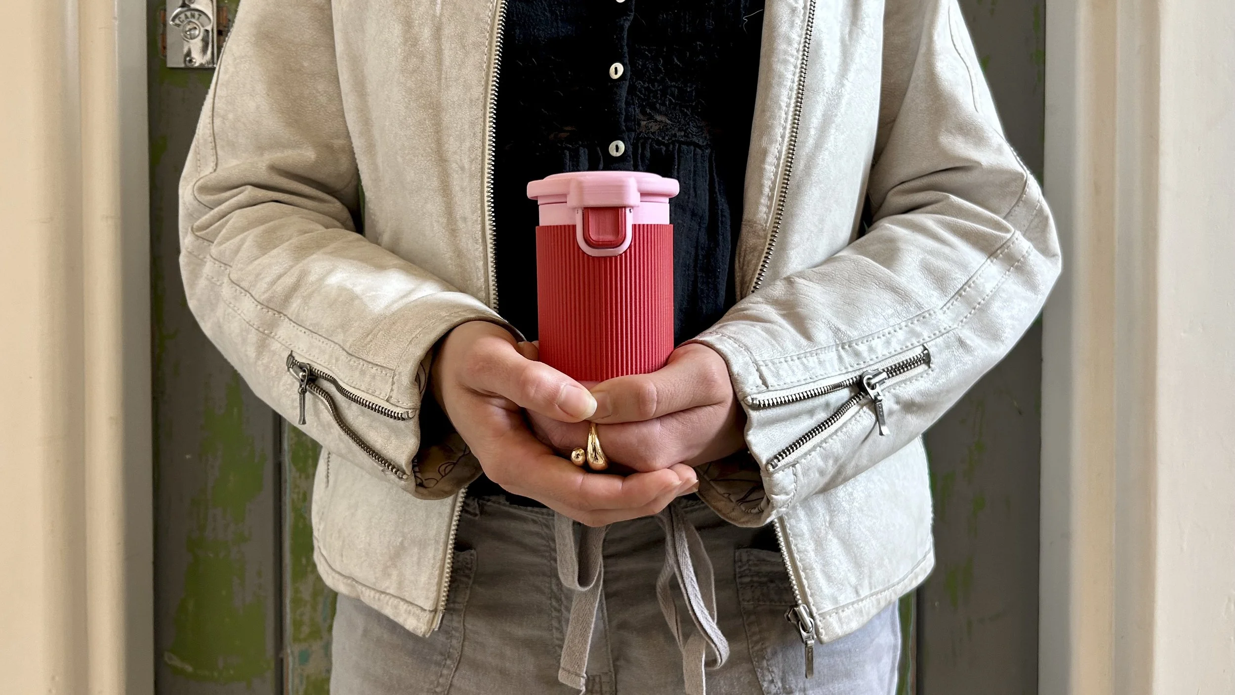 Person holding Halo menstrual cup rinsing pod in the Very Berry colourway with both hands