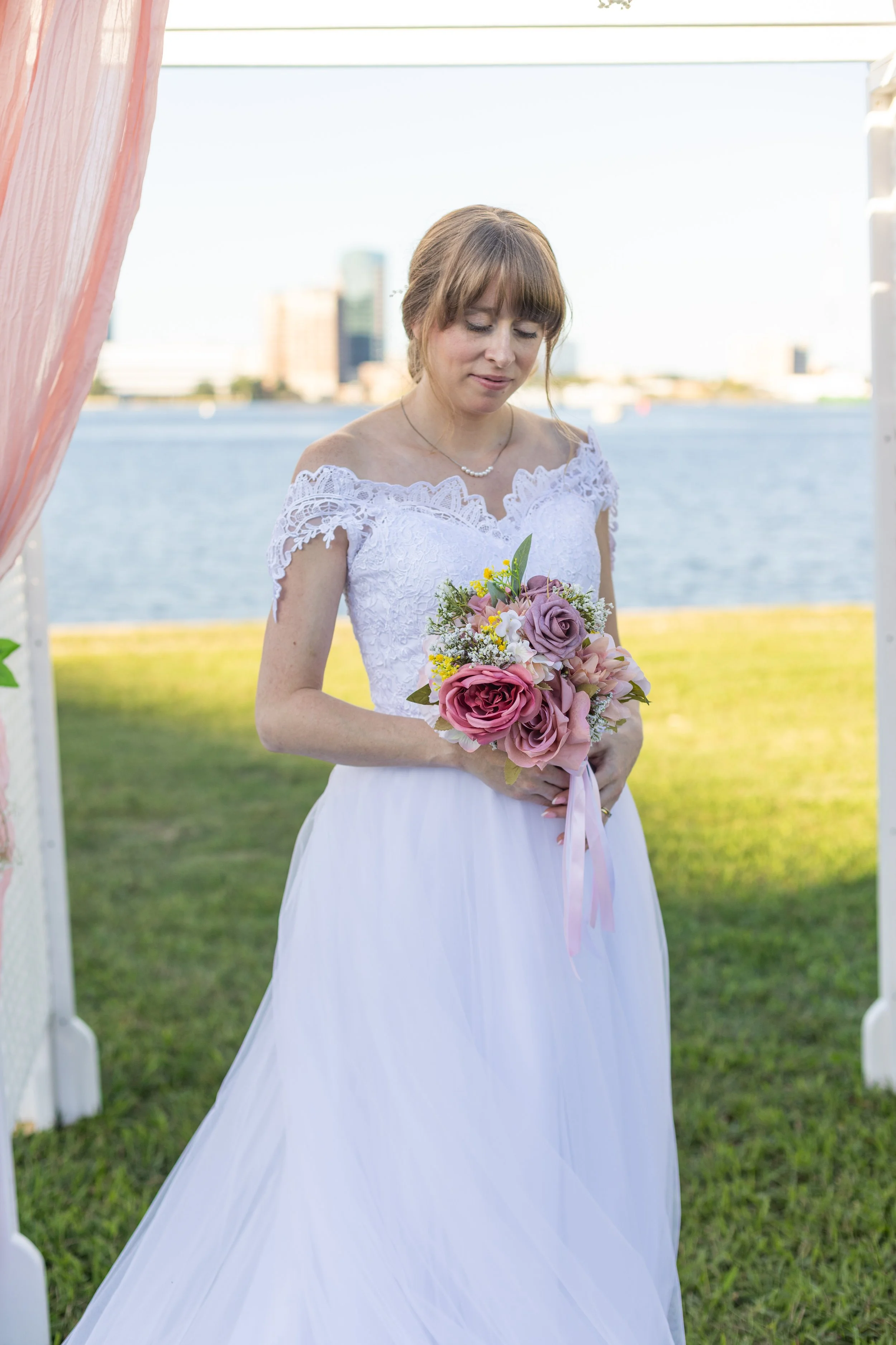 Bride in front of Chesapeake Bay in Norfolk, Virginia after her wedding. Taken by Wedding Photographer Sarah Quiles.