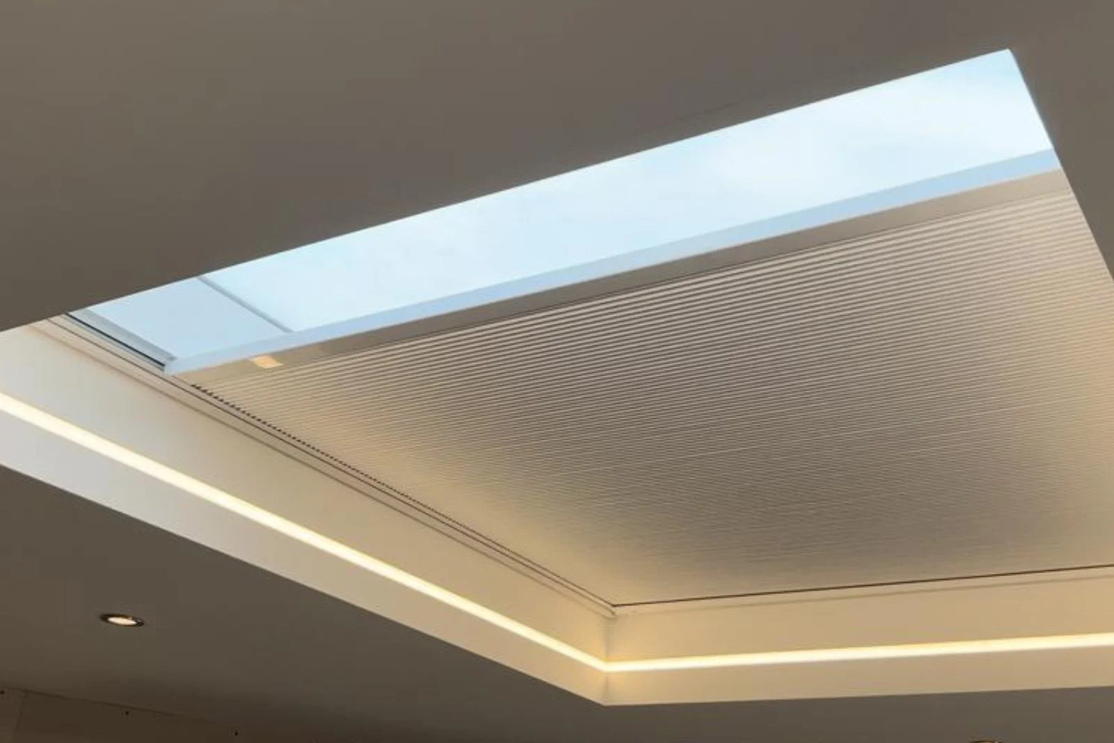 Ceiling with built-in recessed lighting and a large rectangular skylight.