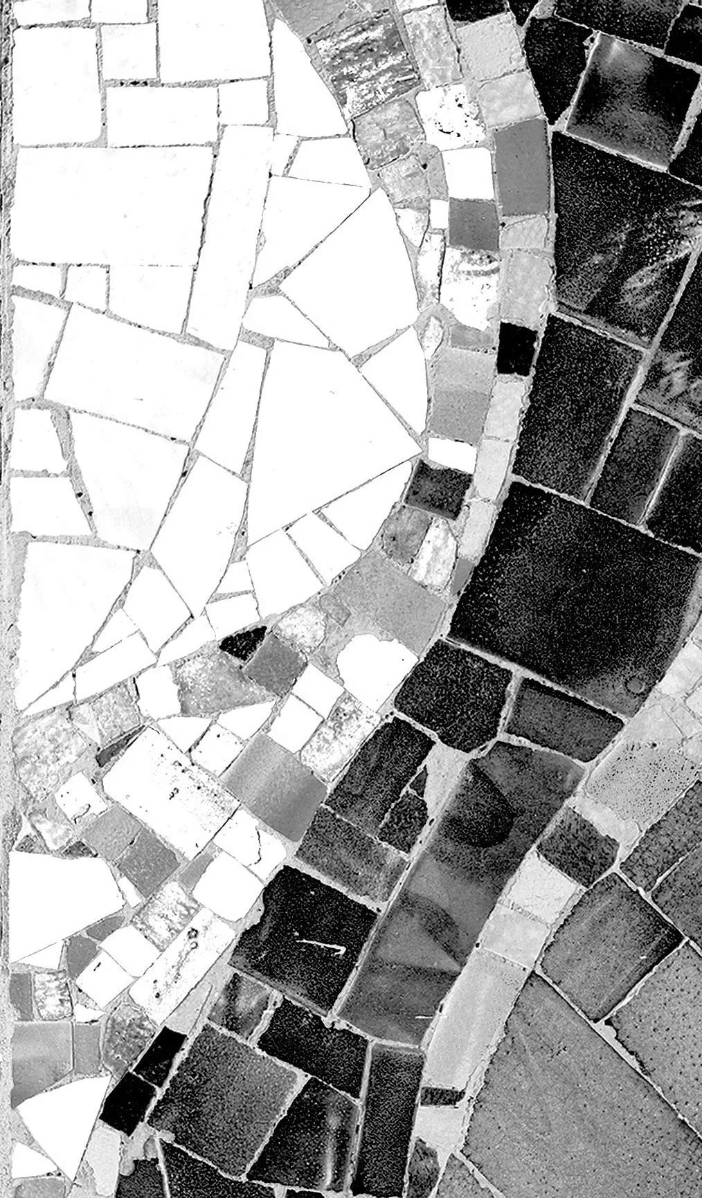 A black and white photo of a mosaic tiled floor with various shapes and sizes of tiles arranged in a decorative pattern.