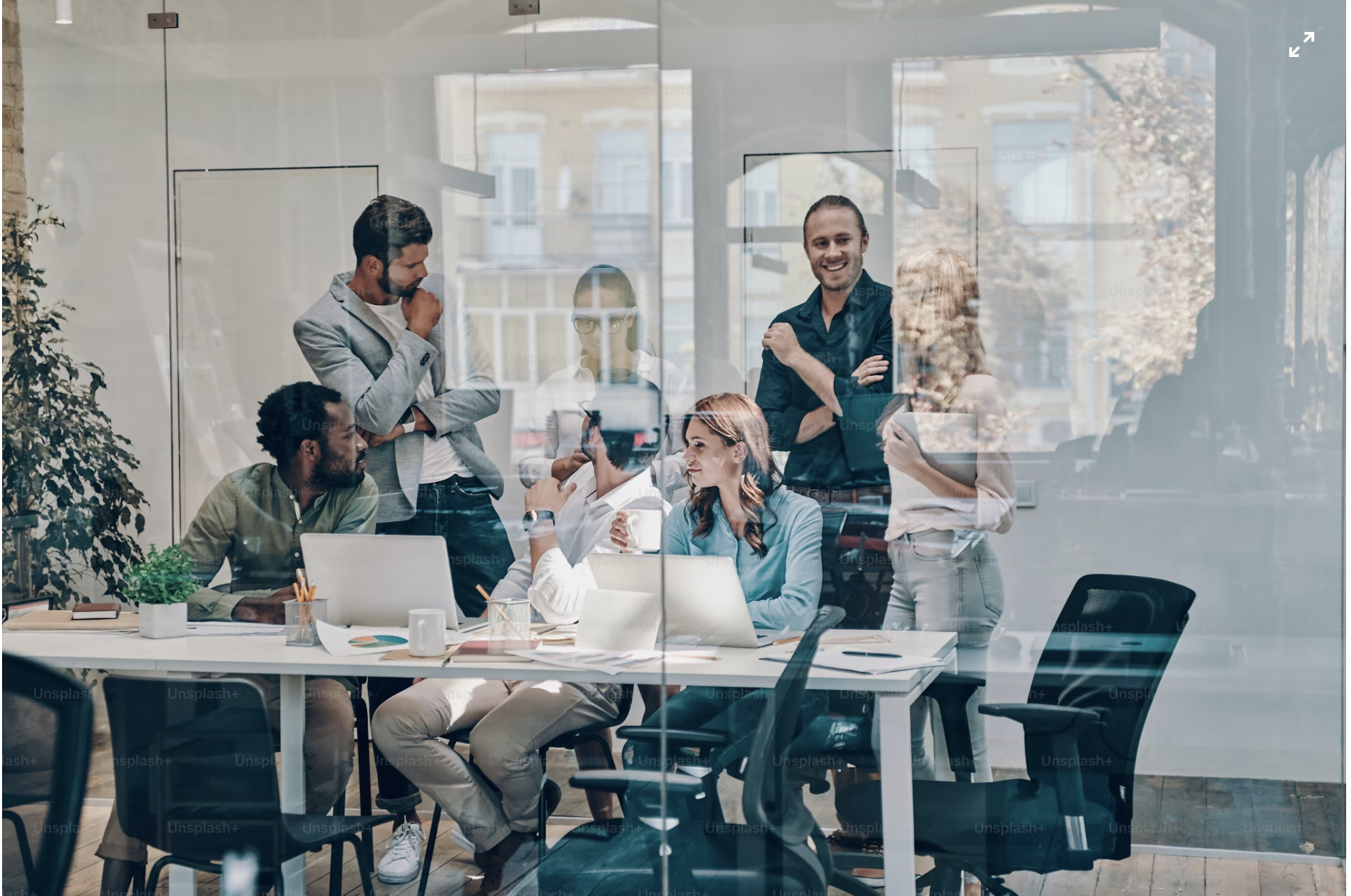 Group of professionals having a discussion in a modern conference room with large glass windows