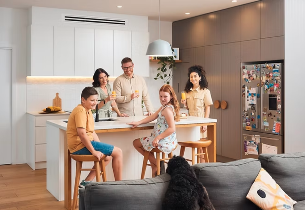 Family gathered in kitchen under discreet ducted air conditioning vent