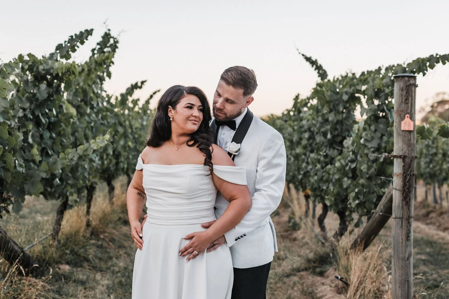 Mountains with snow in the background and a modern building in the foreground on a grassy hillside.