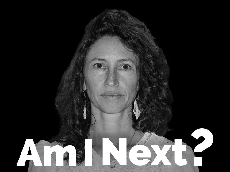 Black and white portrait of a woman with curly hair, wearing earrings, with the text "Am I Next?" in bold white letters at the bottom.