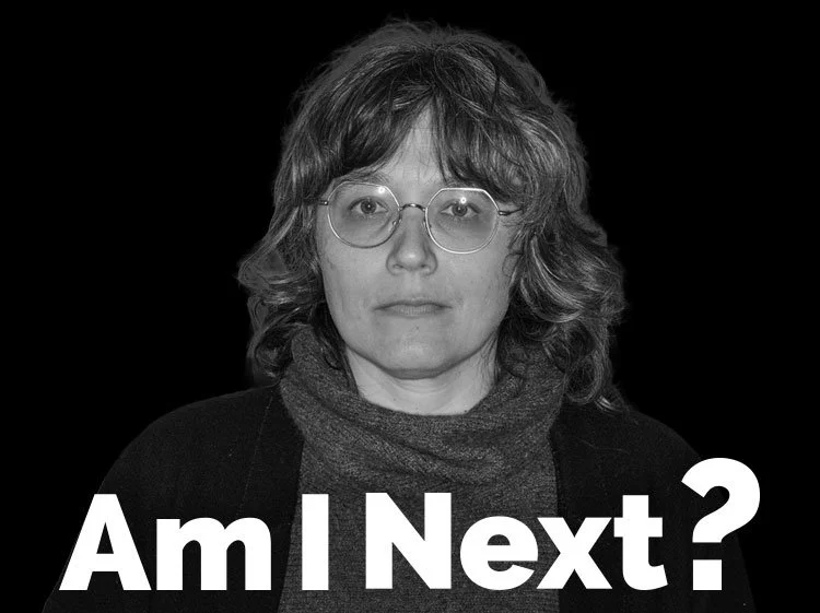 A black and white photo of a woman with shoulder-length curly hair, wearing glasses and a dark jacket with a scarf, with the text "Am I Next?" in large font overlaying the bottom of the image.