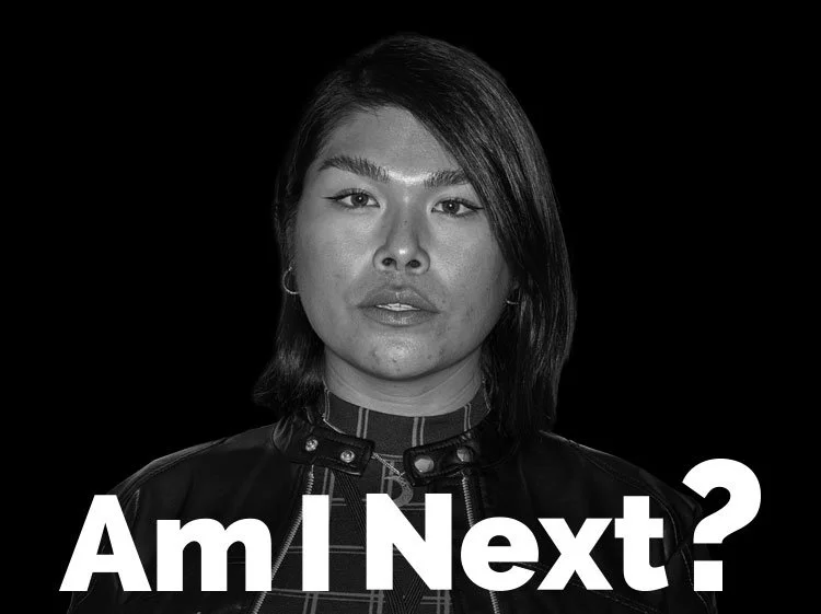Black and white portrait of a woman with shoulder-length hair, wearing a leather jacket and a striped shirt, looking directly at the camera with the text "Am I Next?" in bold white letters at the bottom.