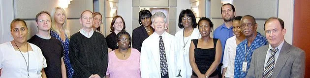 Group of diverse professionals in an office setting, smiling for a photo.