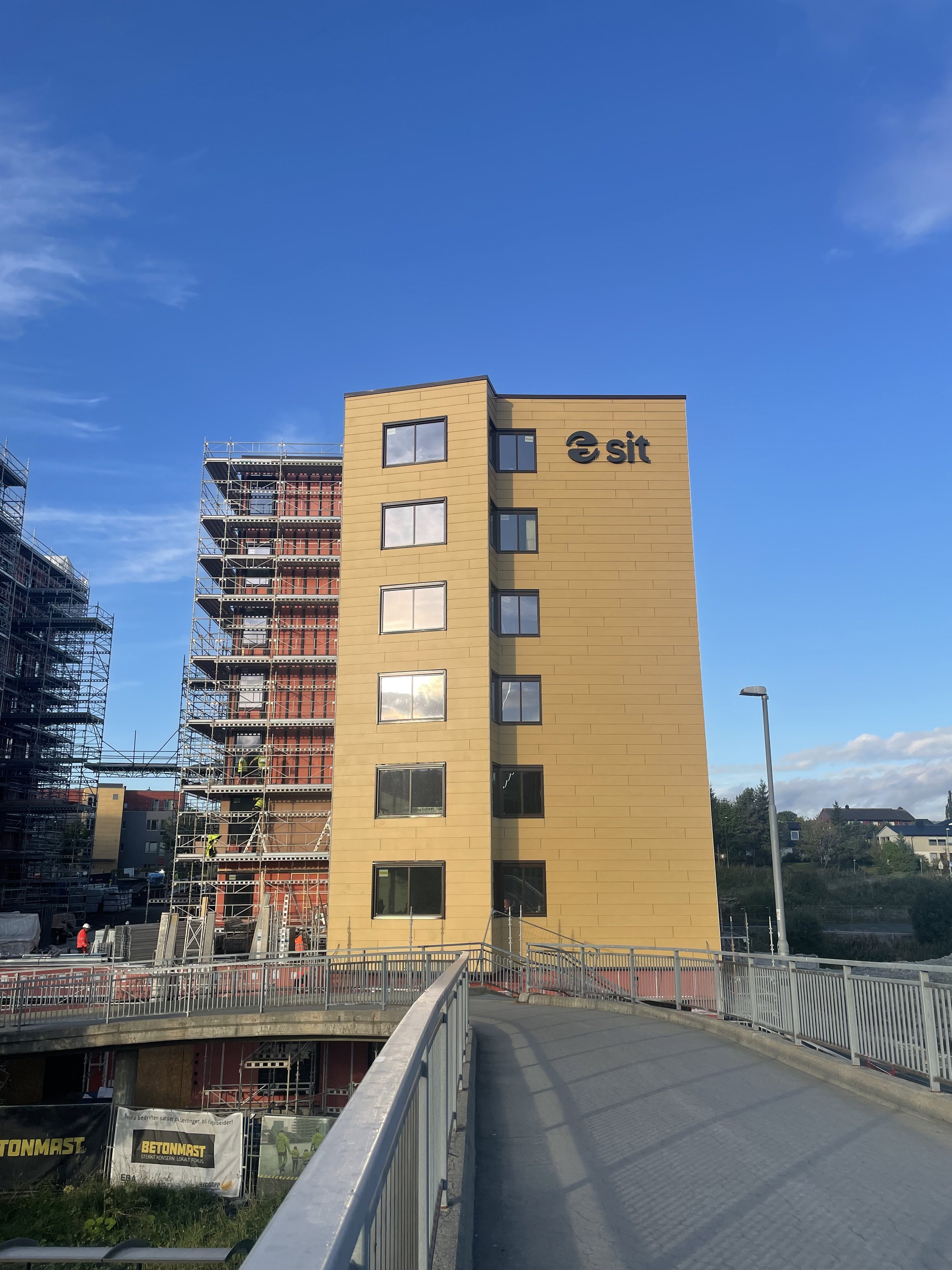Nytt bygget med fasade i beige panel, flere vinduer og logoen Sit som fasadeskilt på den øverste delen.