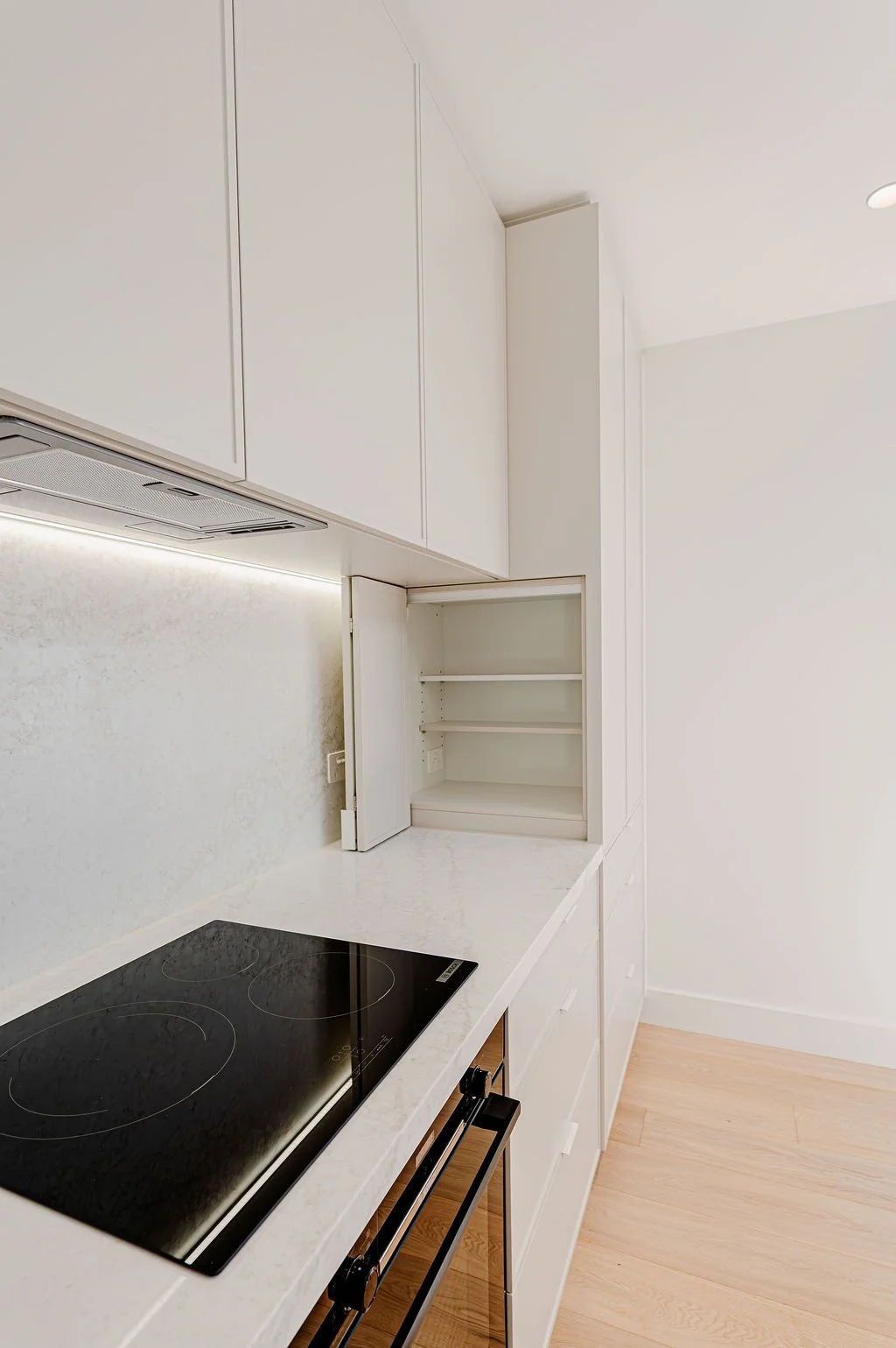 Simple white kitchen with stone benchtops.