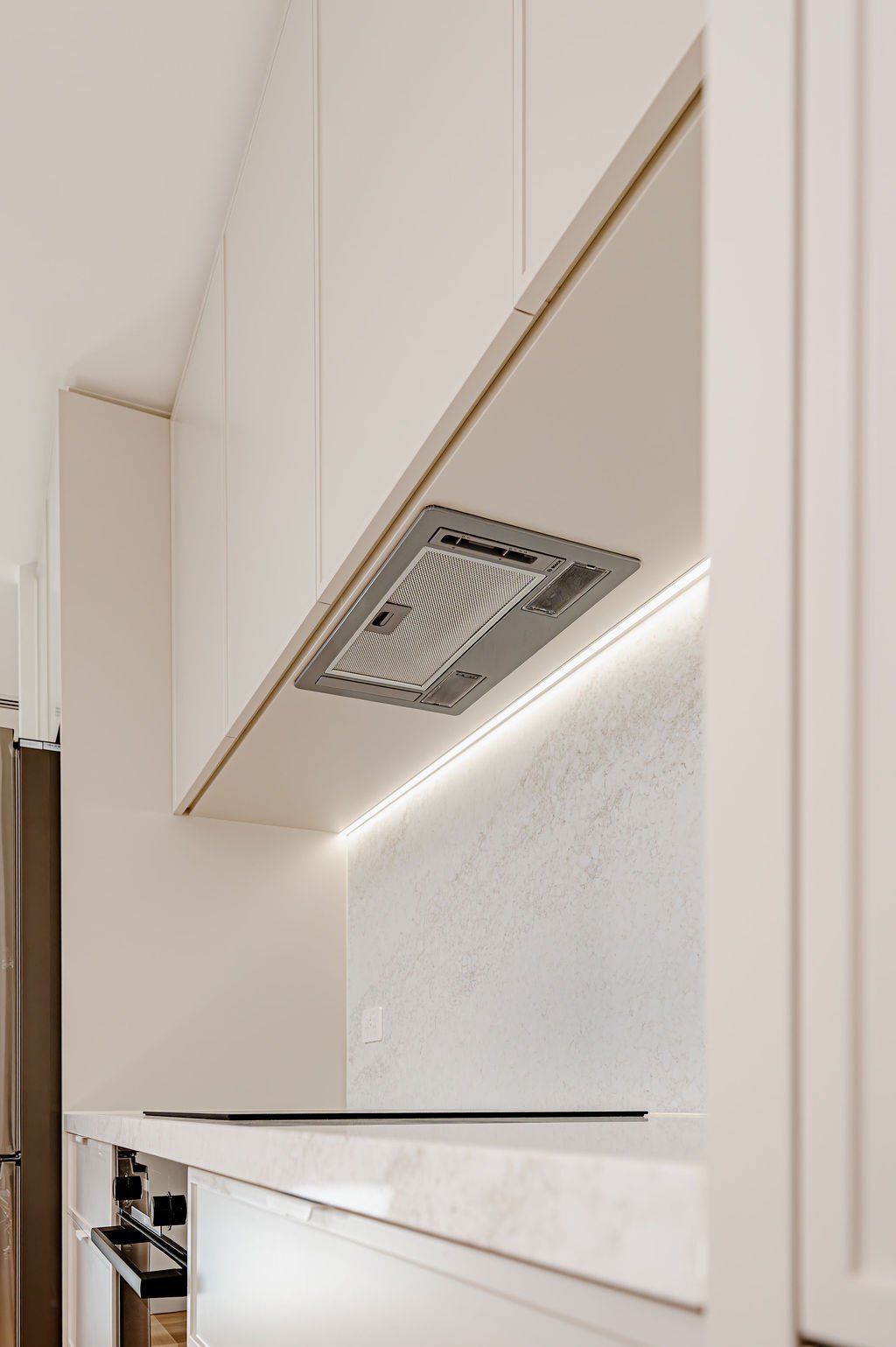 Simple white kitchen with stone benchtops.