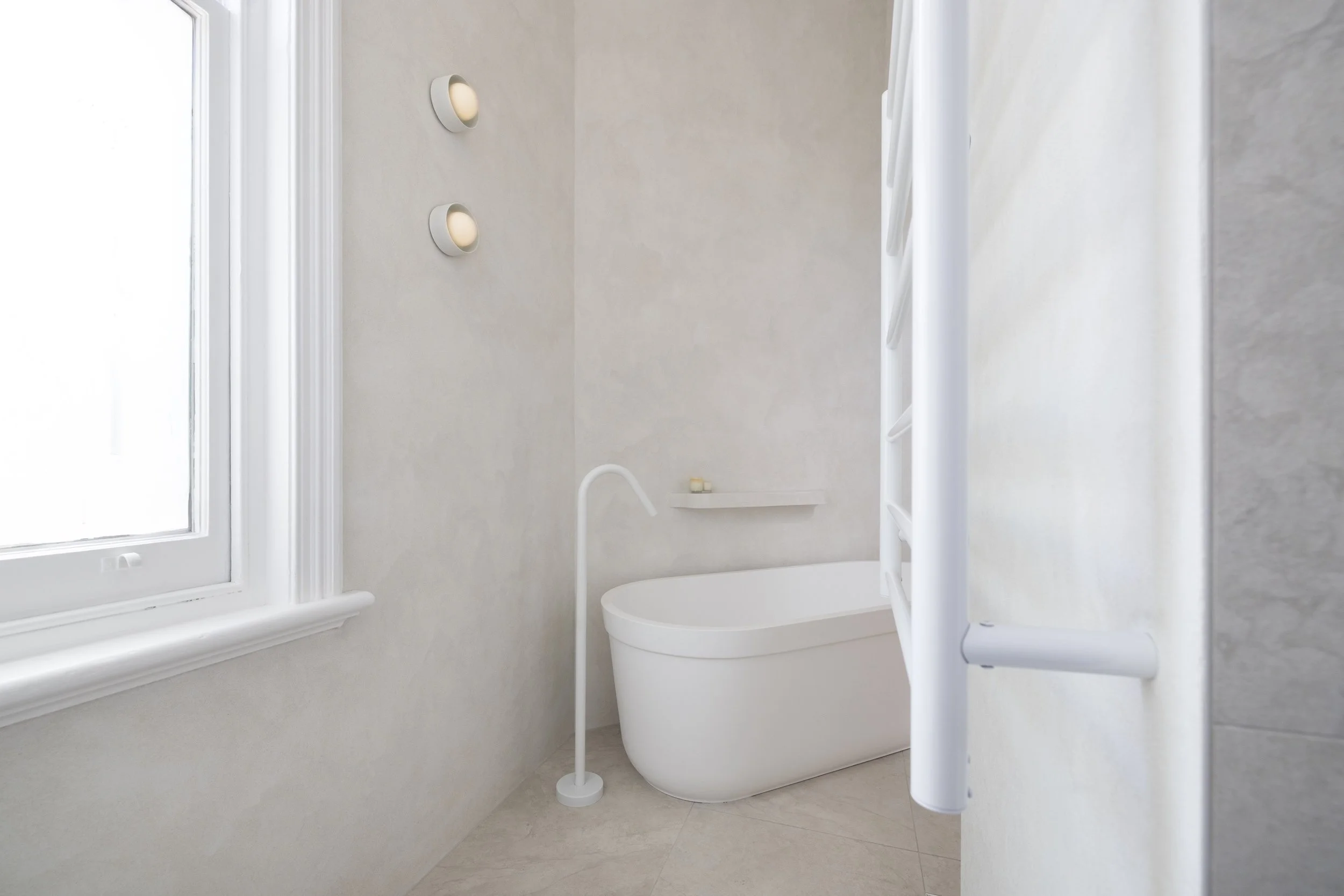 White bathroom with texture wall finish and with freestanding bath