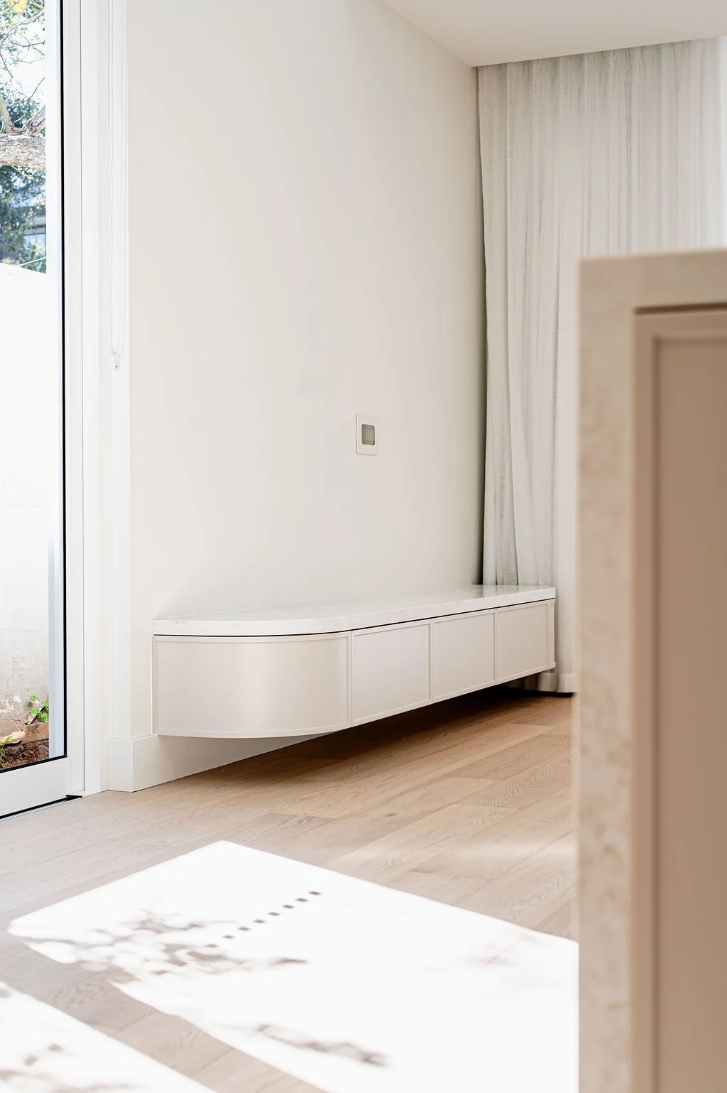White entertainment unit with curved end.