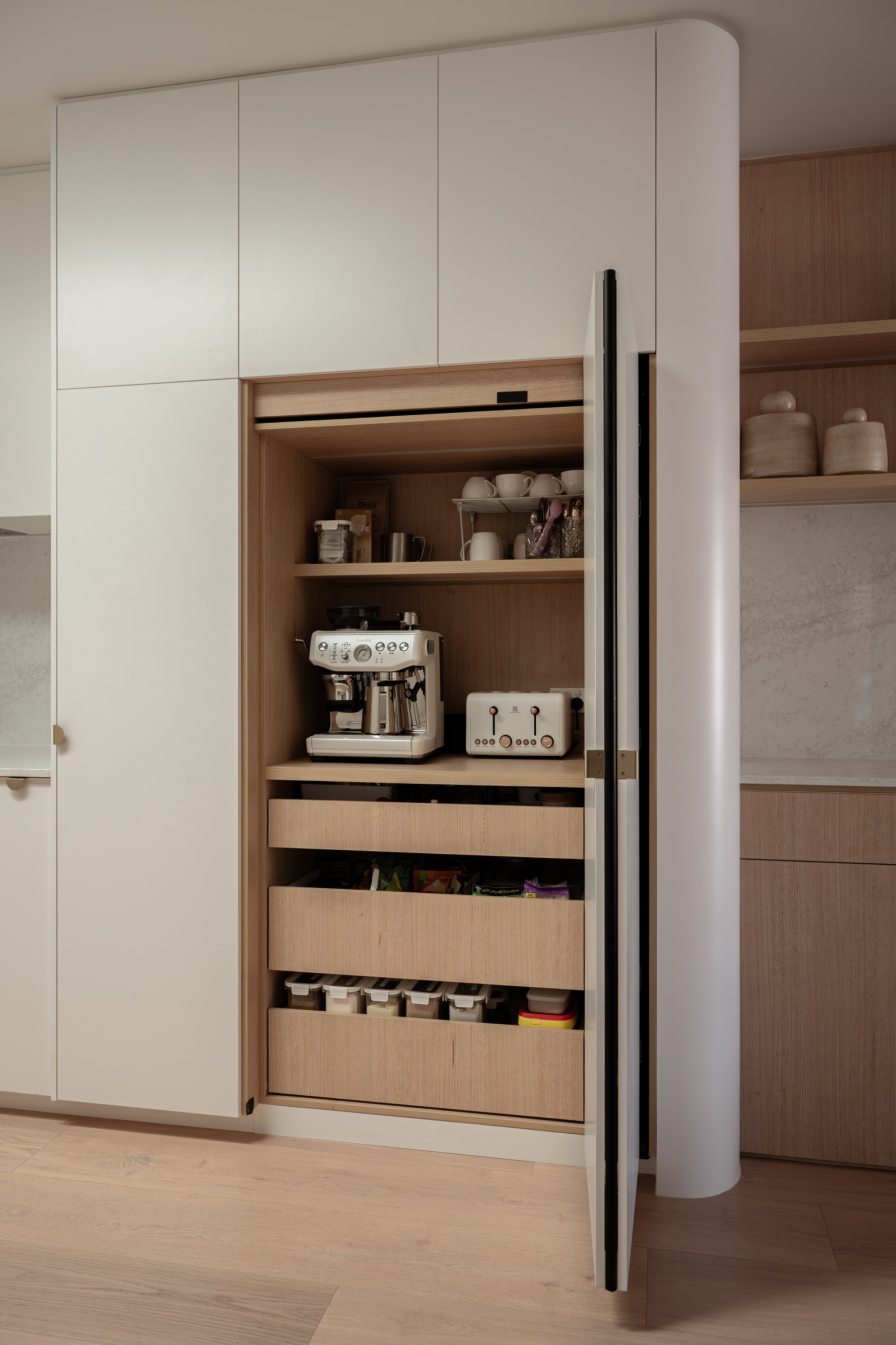 Classic white kitchen with bifold appliance and pantry with timber colour internal, and curved end. 
