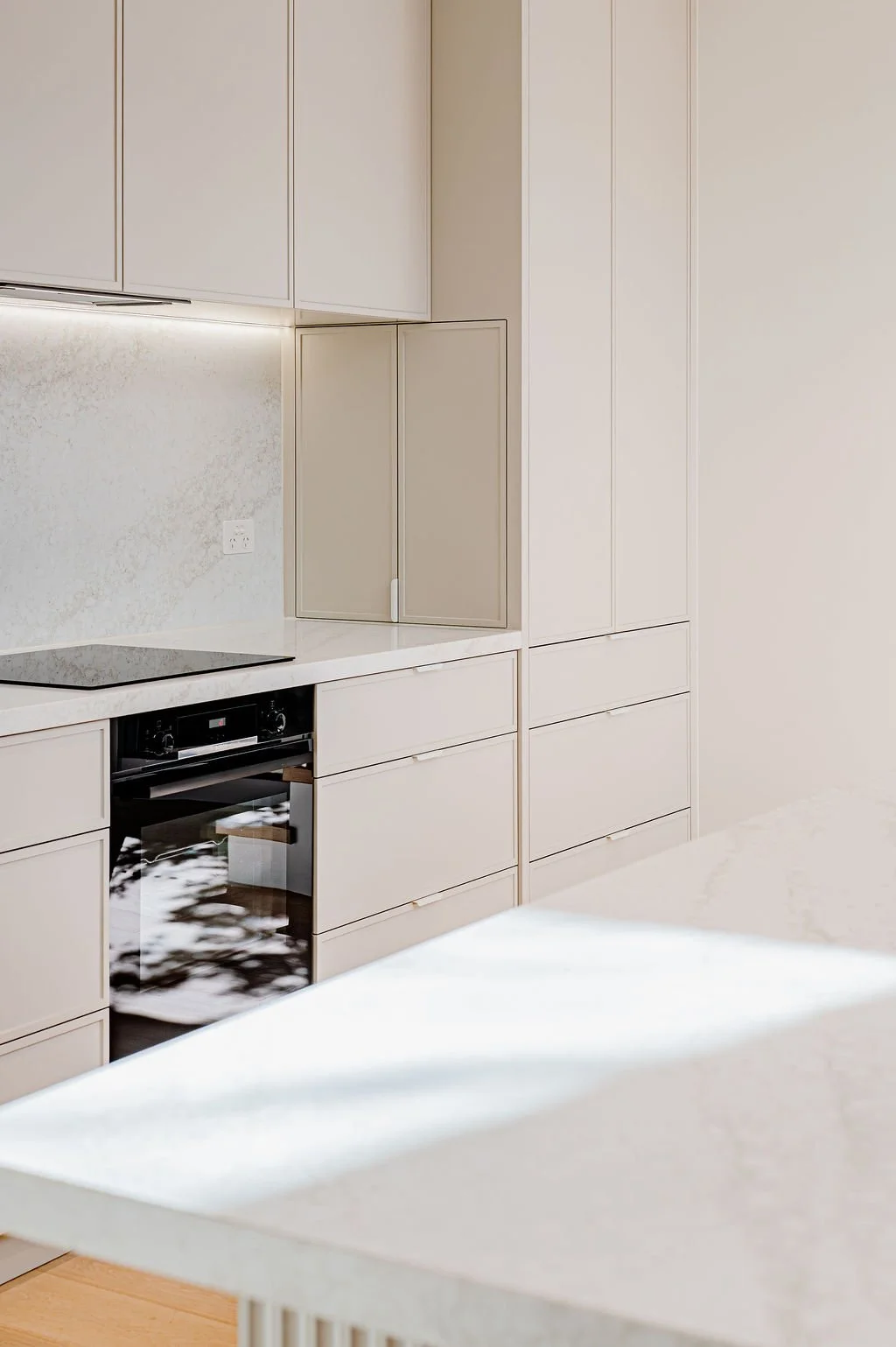 Simple white kitchen with stone benchtops.
