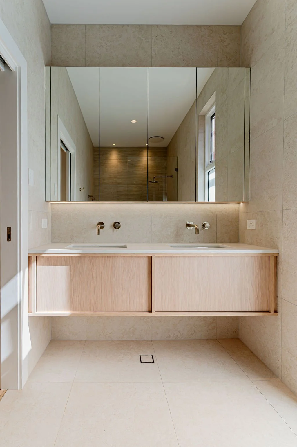 Floating timbergrain vanity with stone benchtop in a neutral bathroom