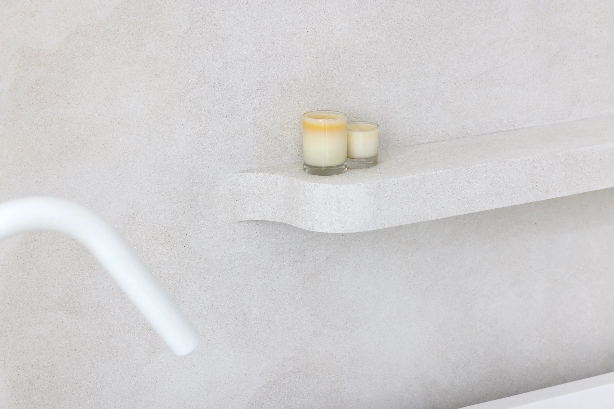 White bathroom with texture wall finish and built in bath shelf