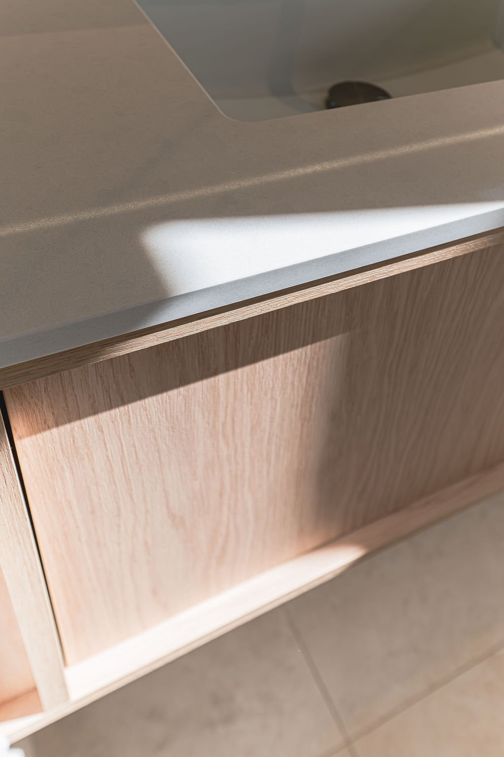 Floating timbergrain vanity with stone benchtop in a neutral bathroom
