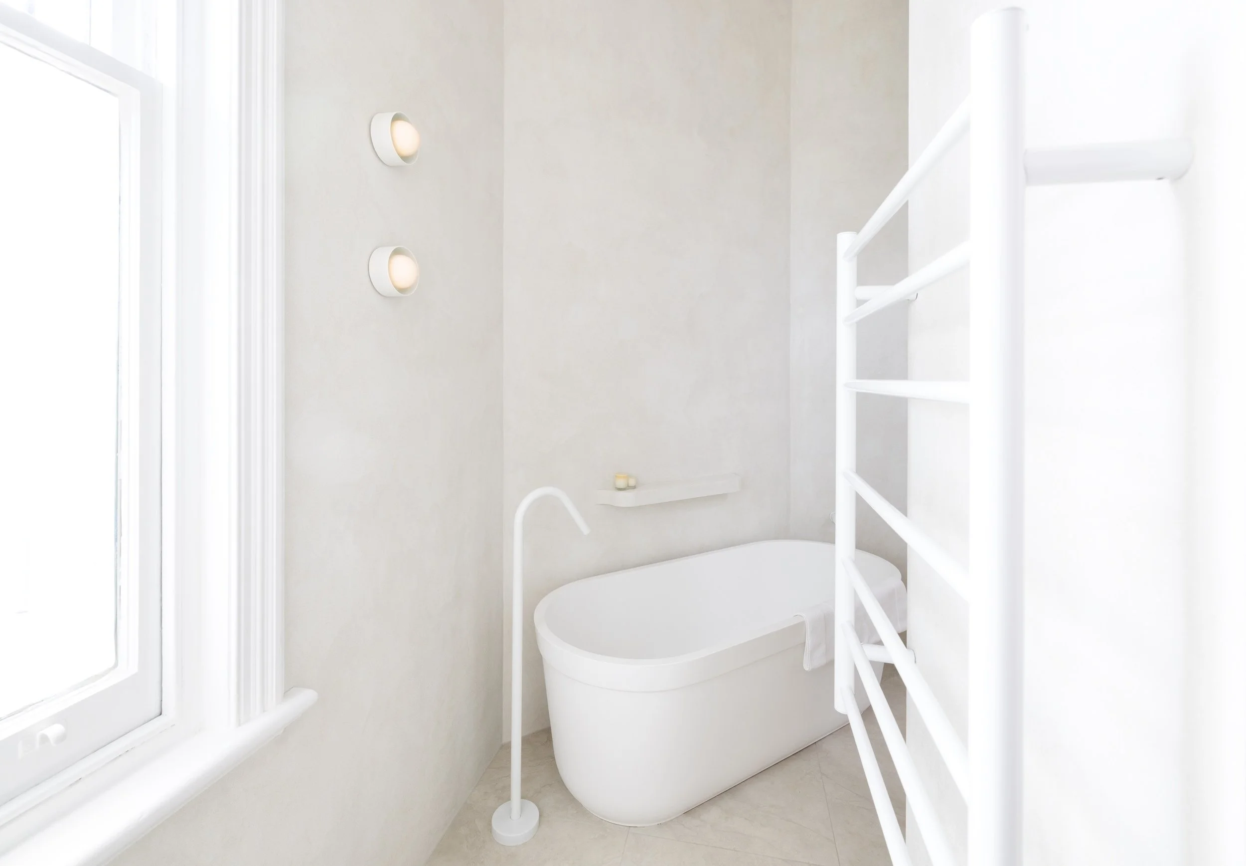 White bathroom with texture wall finish and with freestanding bath