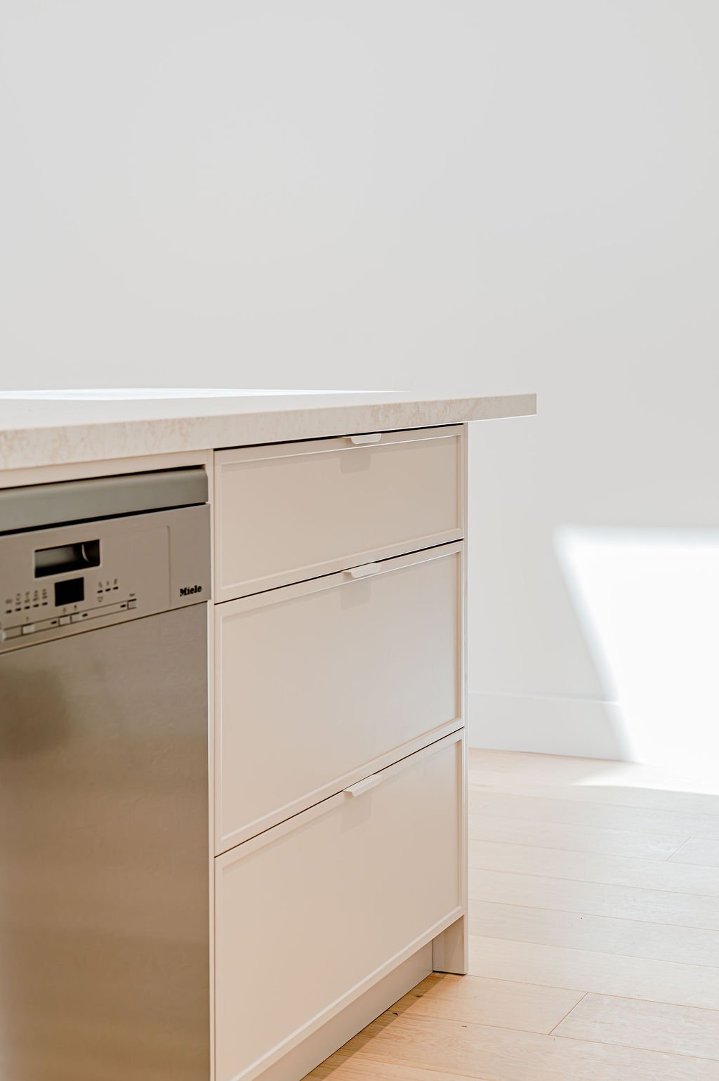 Simple white kitchen with stone benchtops.
