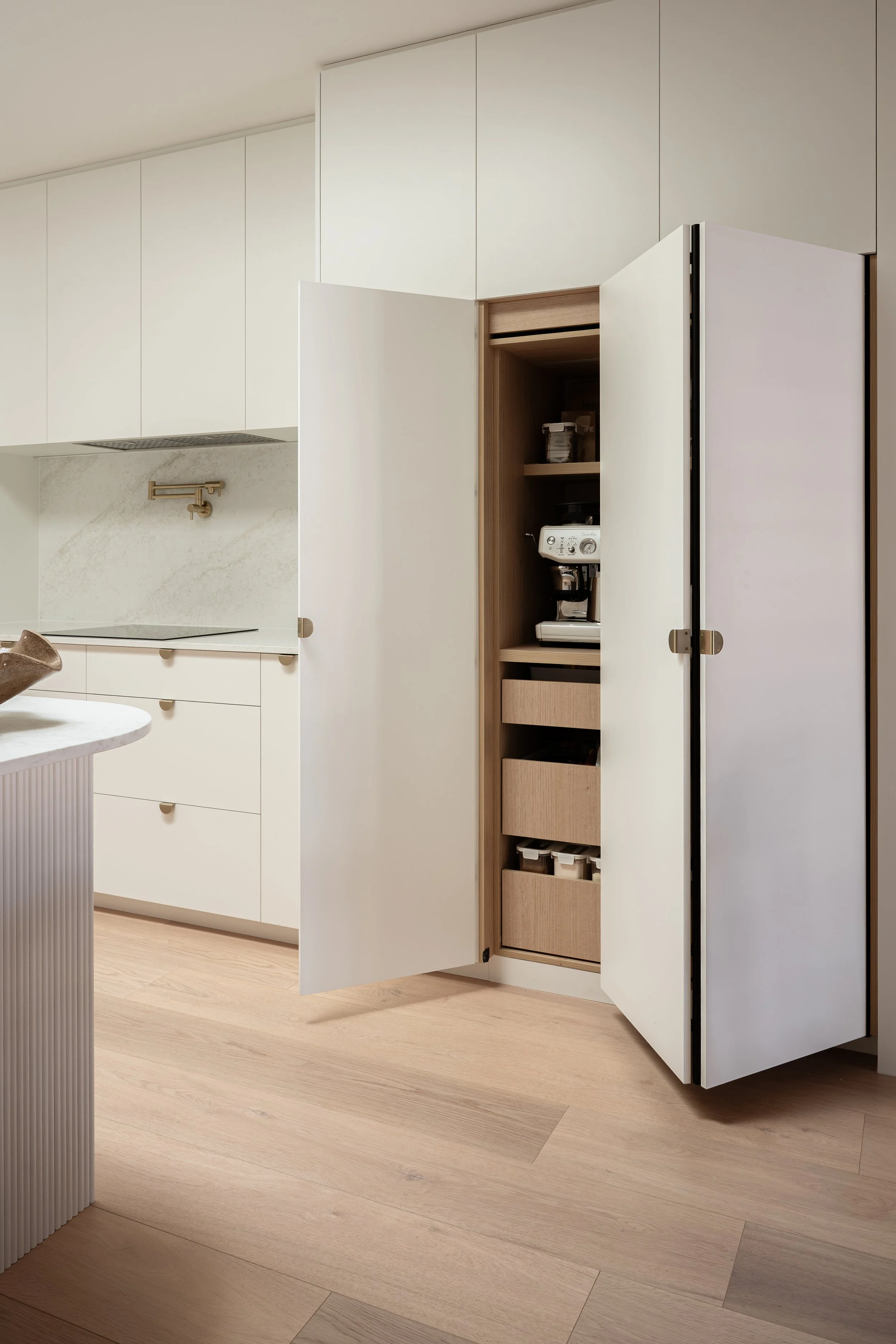 Classic white kitchen with bifold appliance and pantry with timber colour internal, tall pantry for additional storage. 