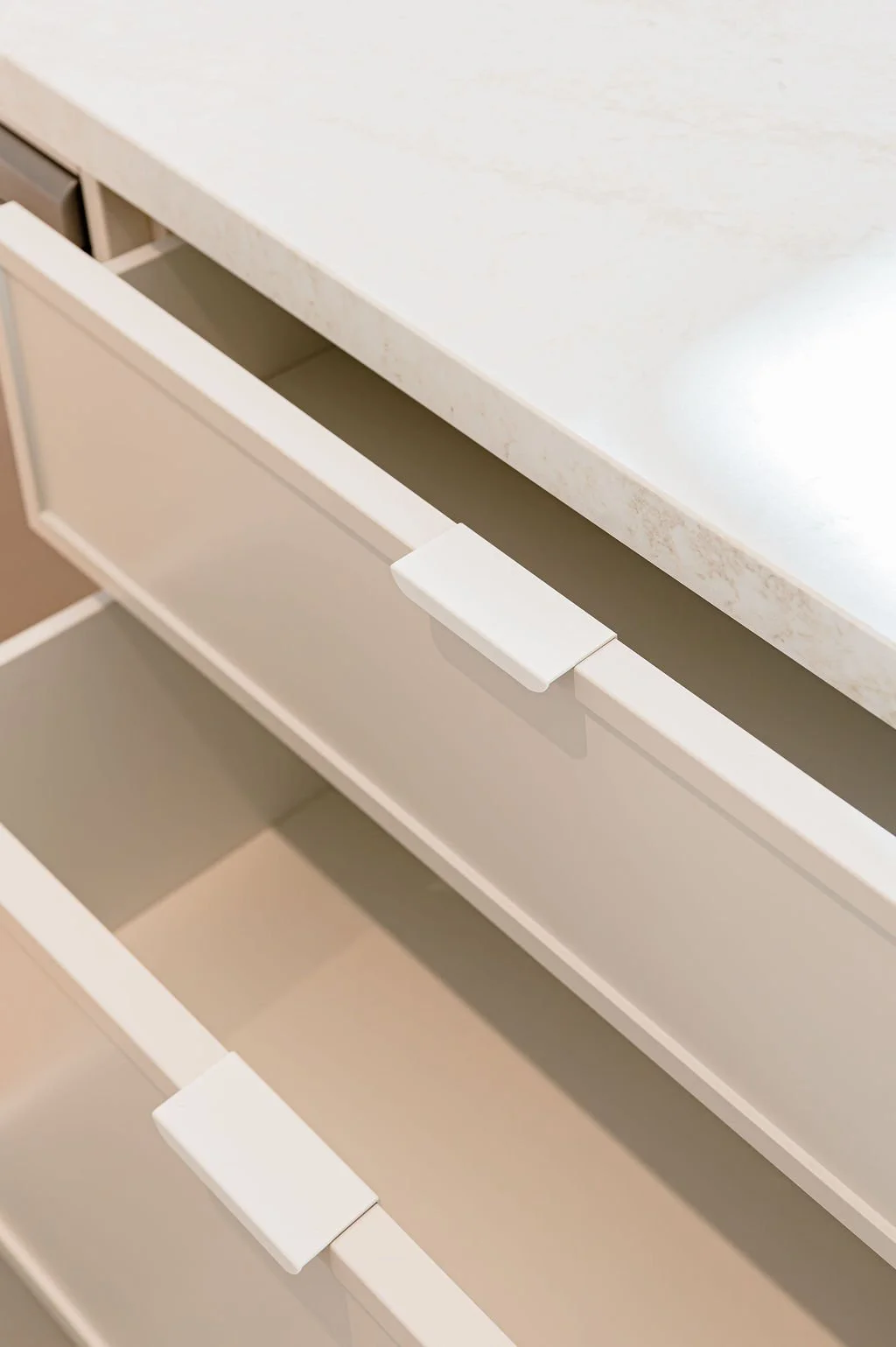 White kitchen drawers with classic profile and lip handle. 