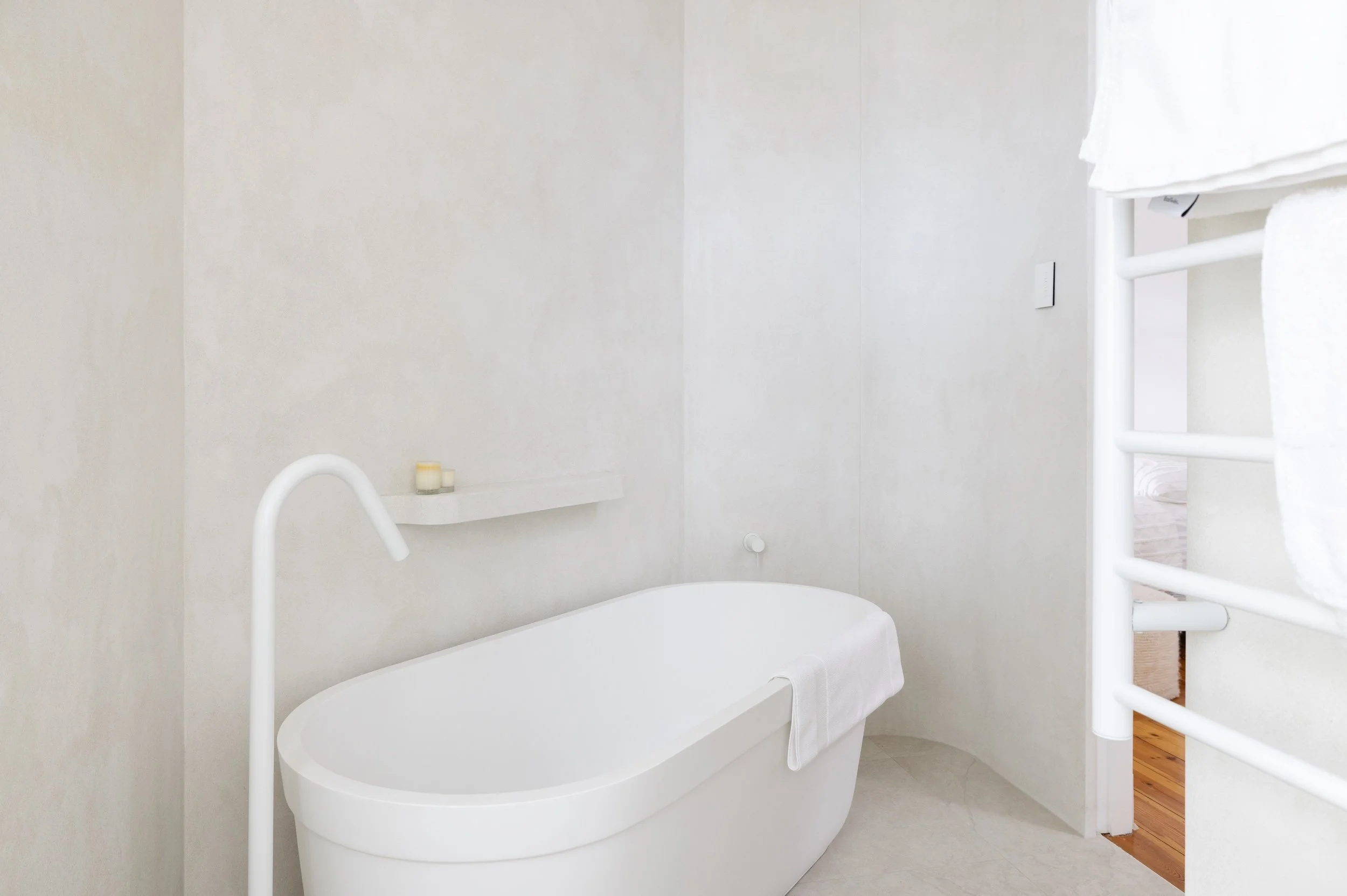 White bathroom with texture wall finish and with freestanding bath