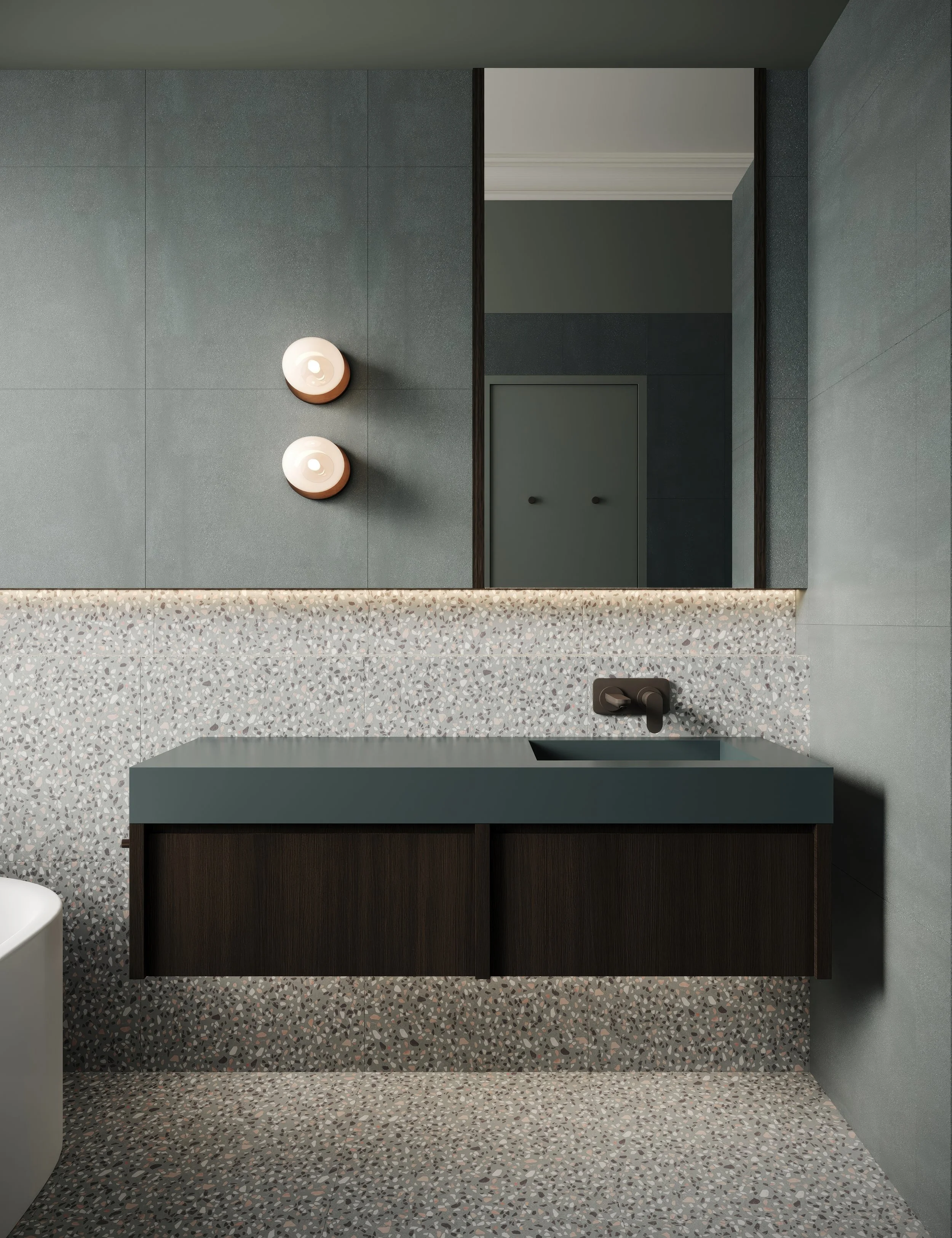Soft green bathroom with dark timbergrain cabinetry, terazzo floors and walls and wall lights. 