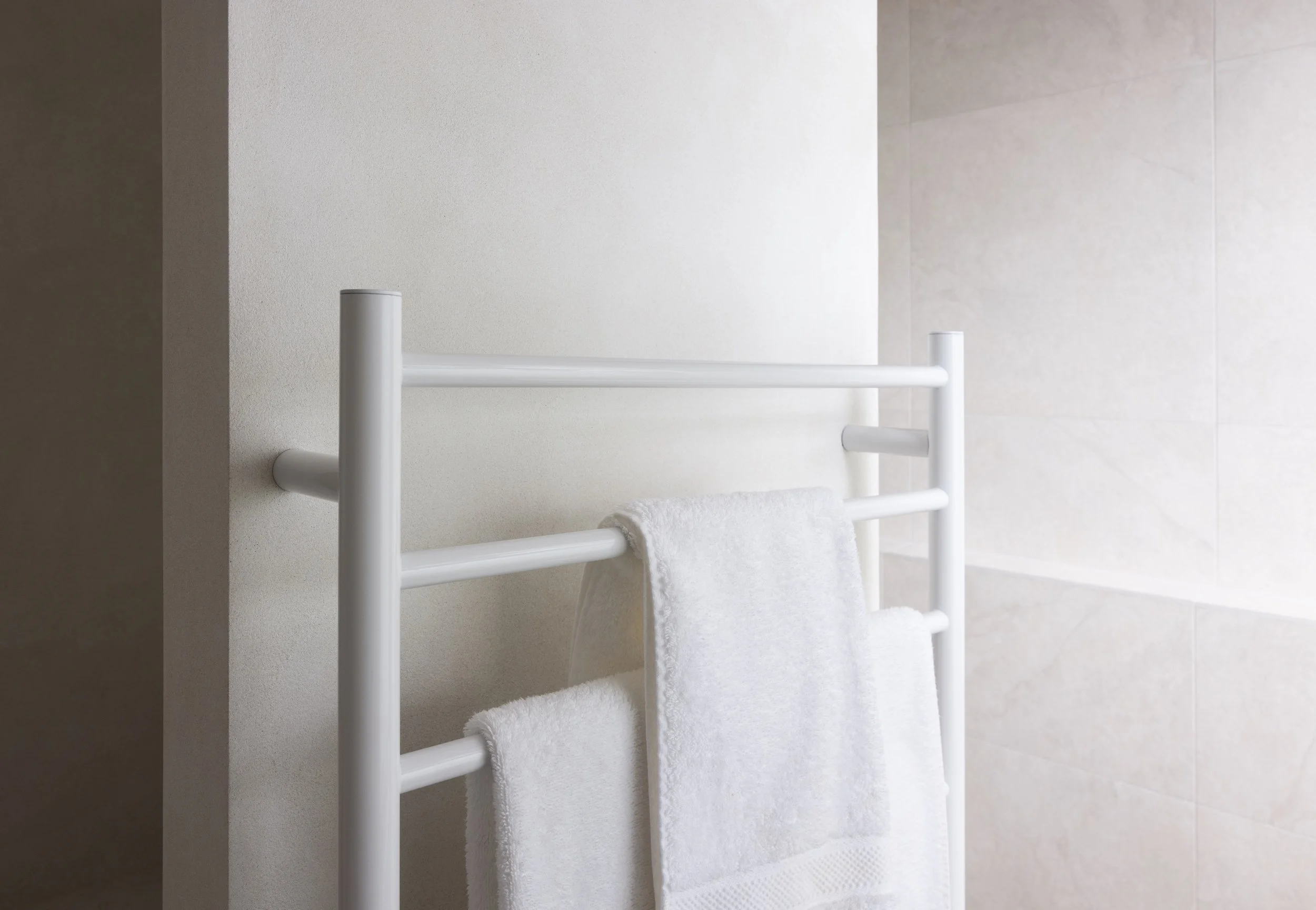 White bathroom with texture wall finish and with white towel rails
