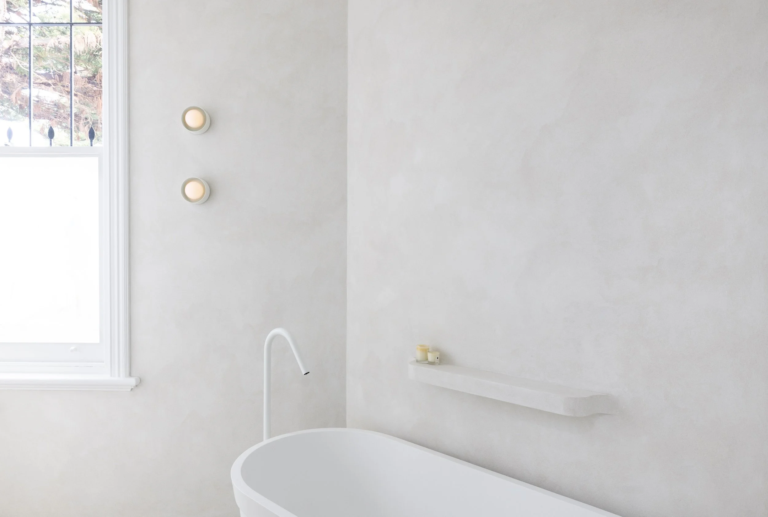 White bathroom with texture wall finish and with freestanding bath