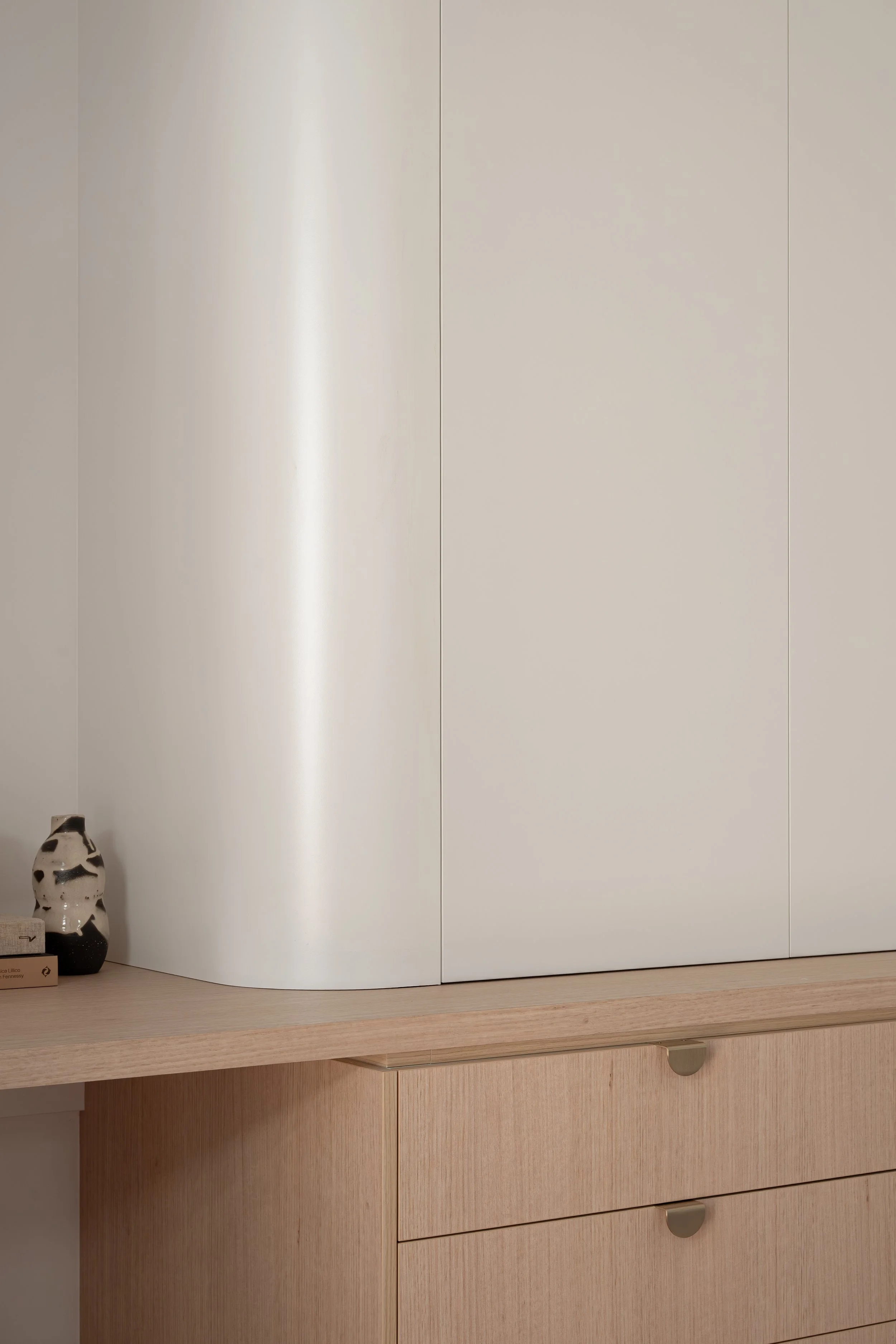 Classic white curved cabinetry paired white timbergrain benchtop and drawers. 