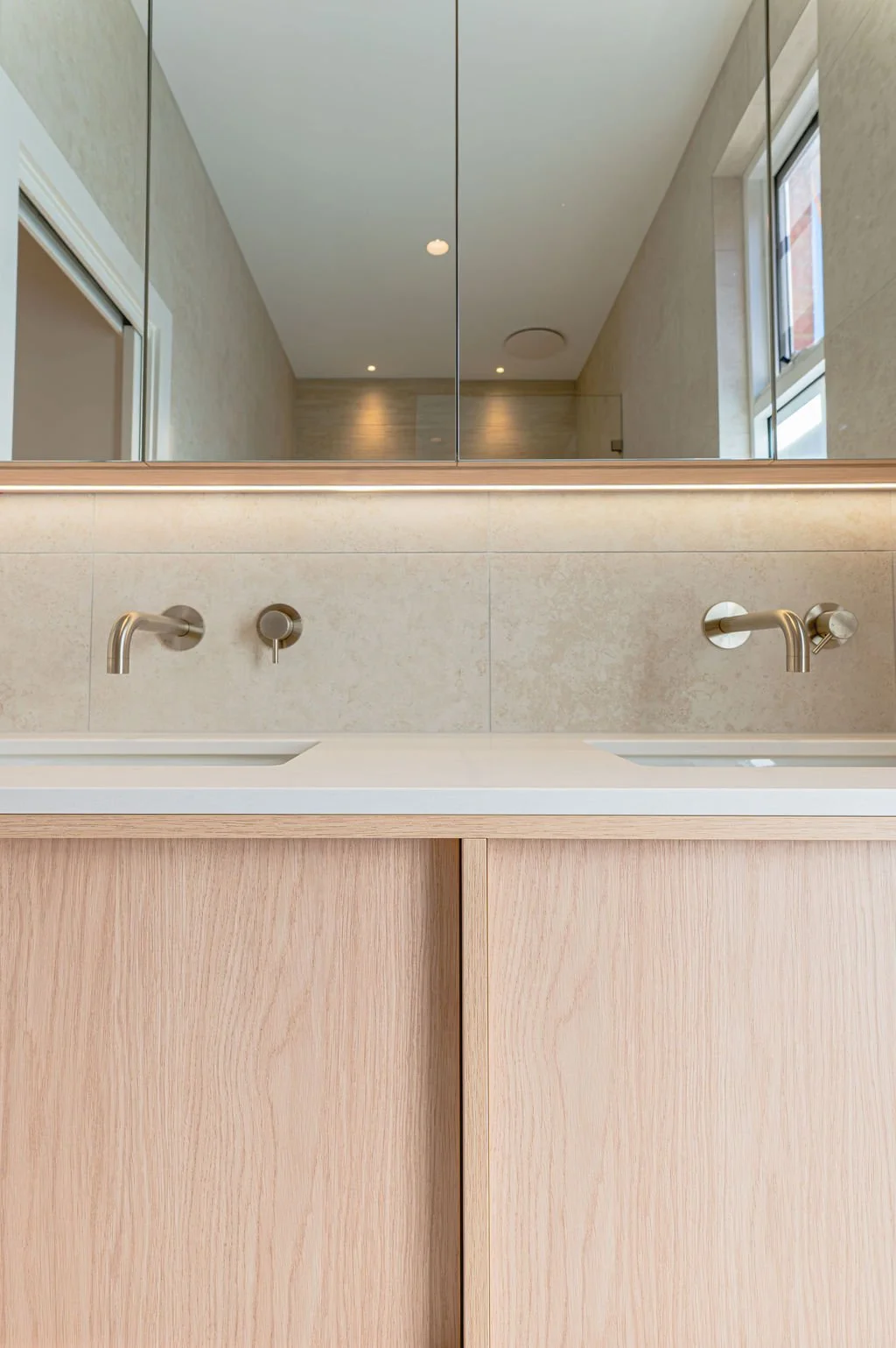 Floating timbergrain vanity with stone benchtop in a neutral bathroom