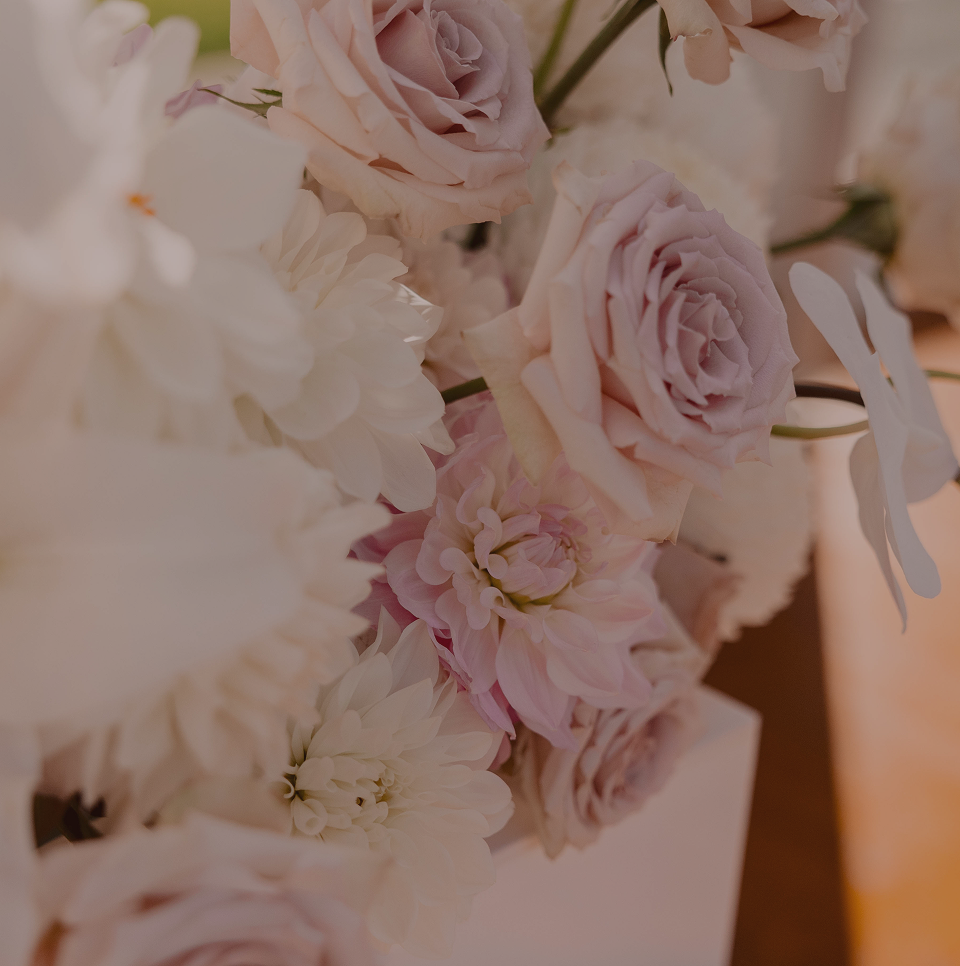 Close-up of an arrangement of pale pink and white roses and dahlias.