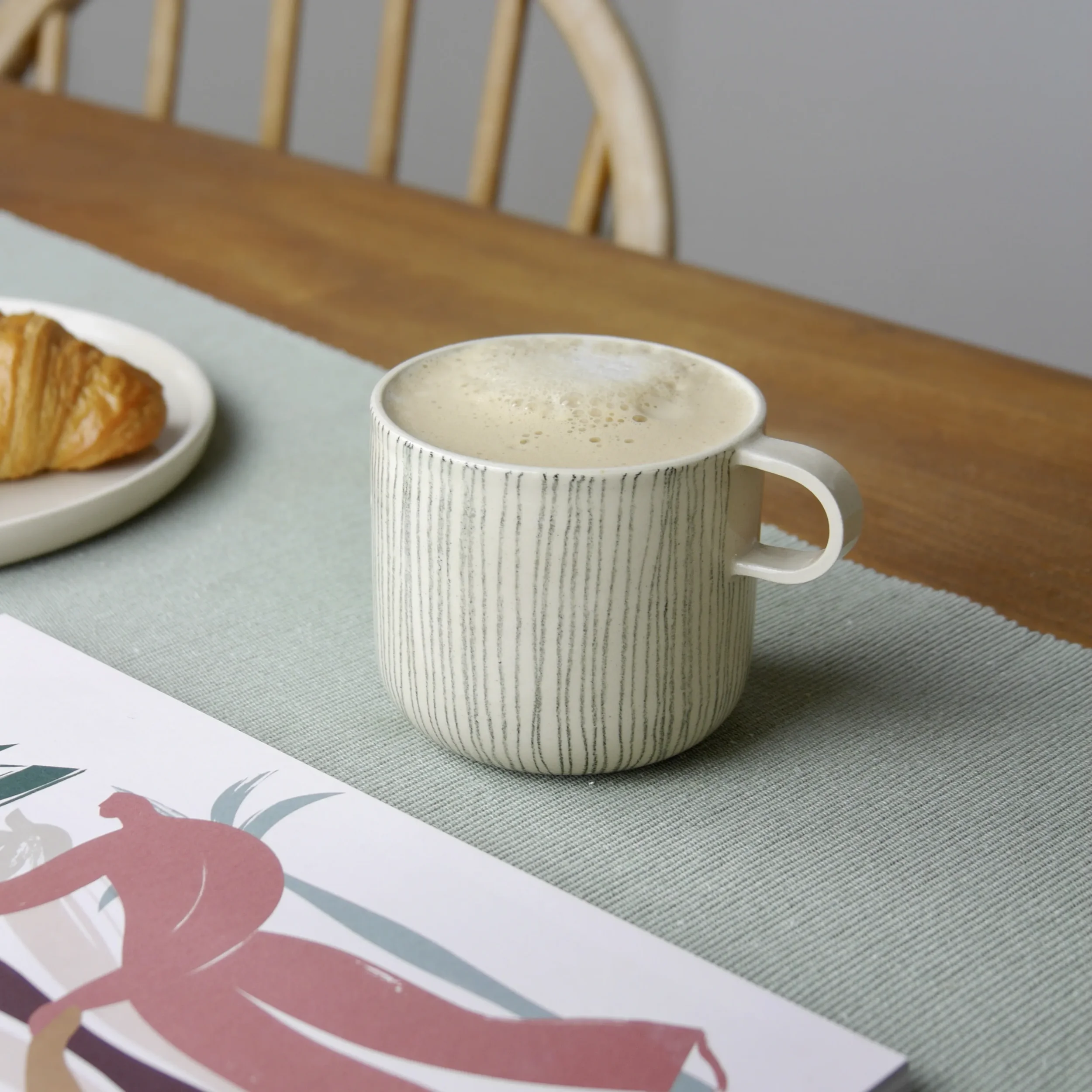 Freehand underglaze pencil linework on Throw to Fire ceramic mug