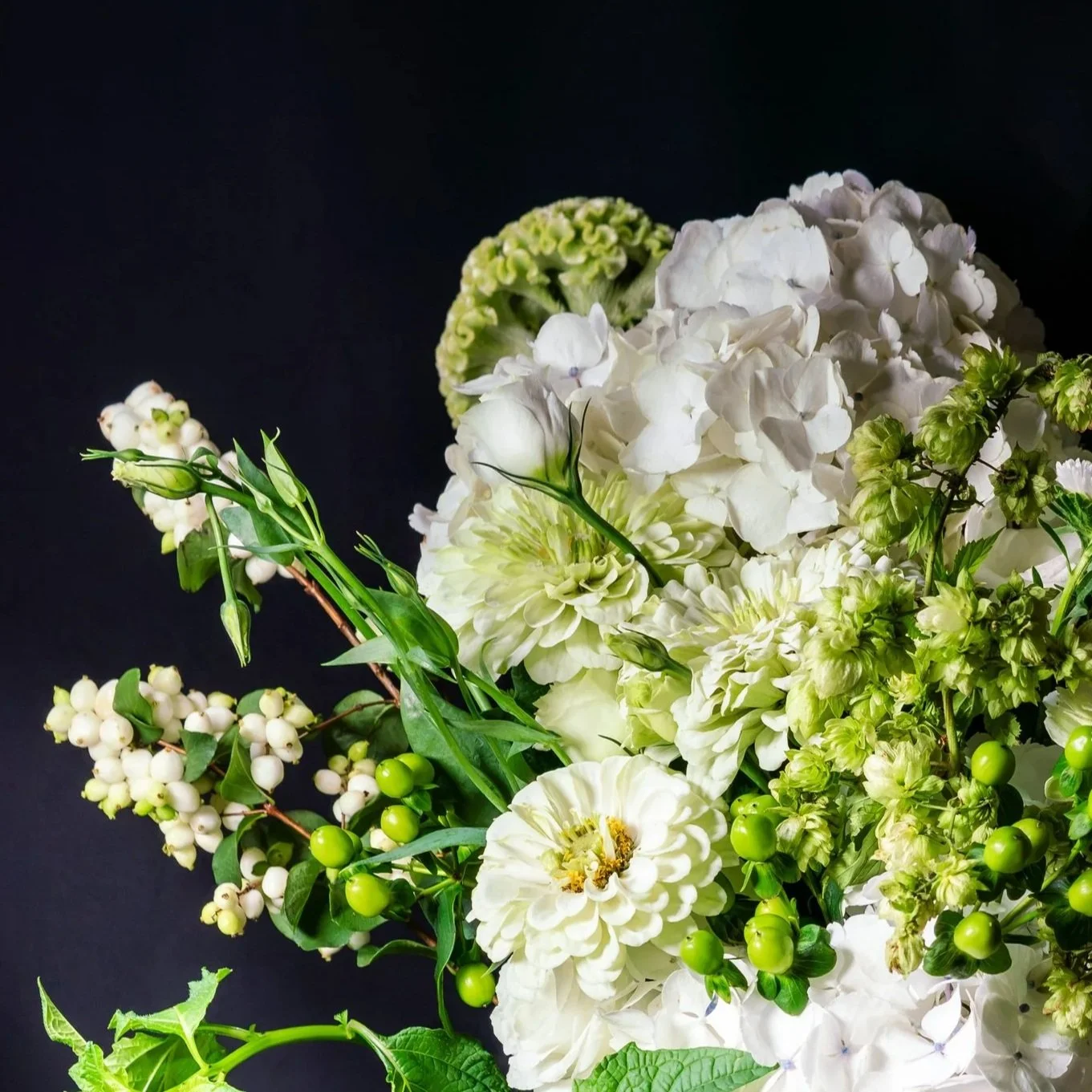 Detail of The Pure One showing white seasonal flowers, fresh green berries and layered botanical textures
